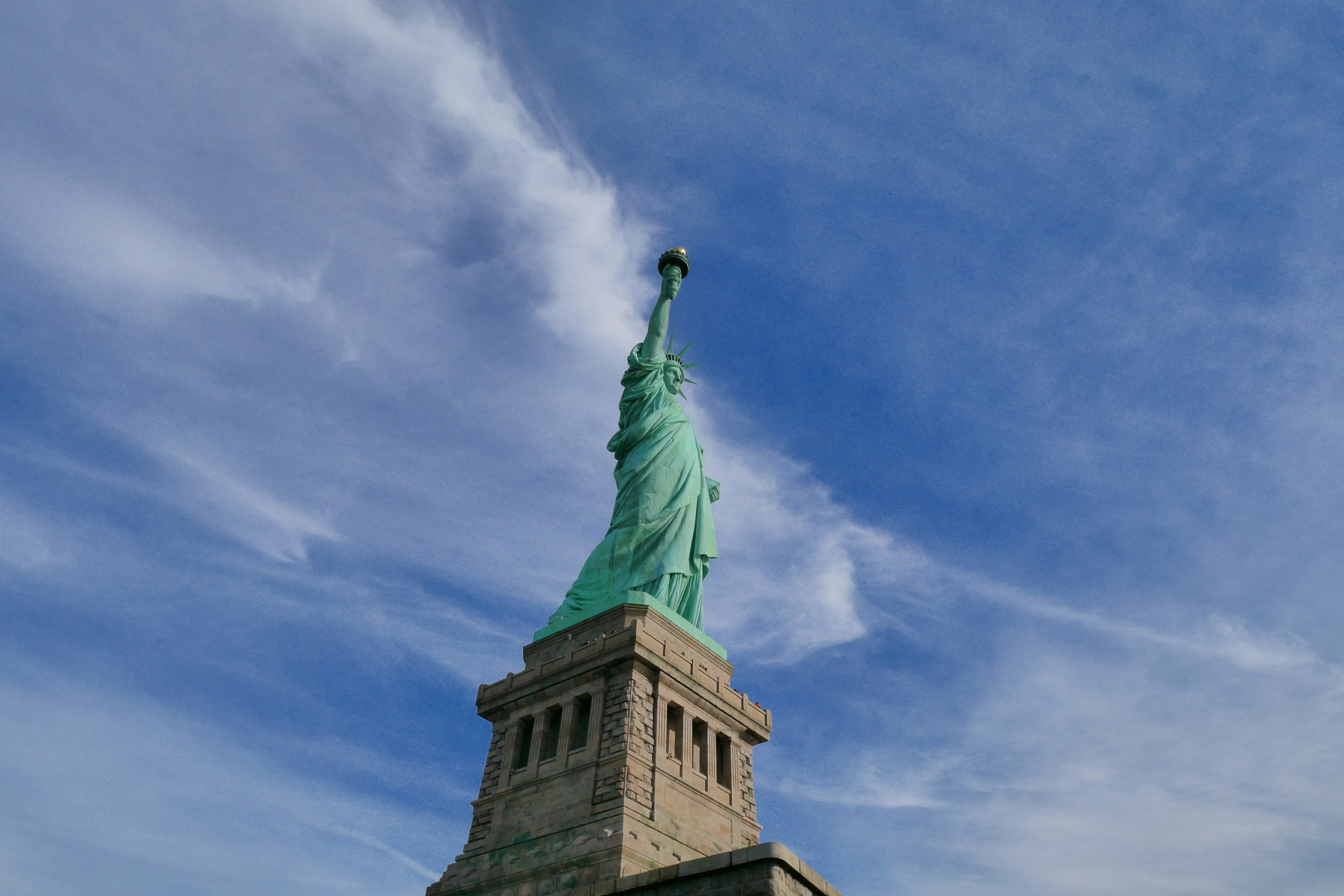 Statue of Liberty stands against a blue sky