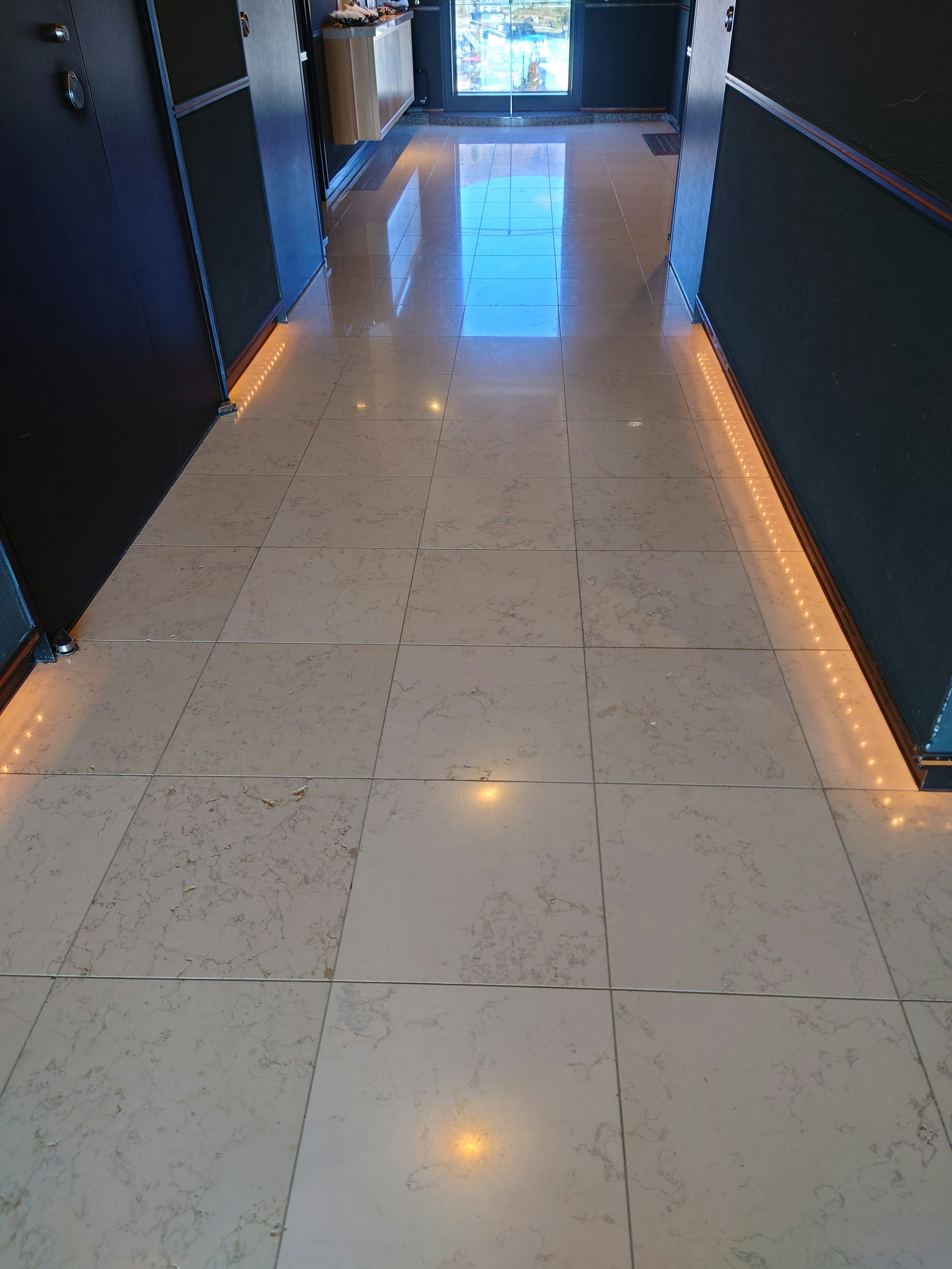 Image of a hallway with marble flooring and bright lighting