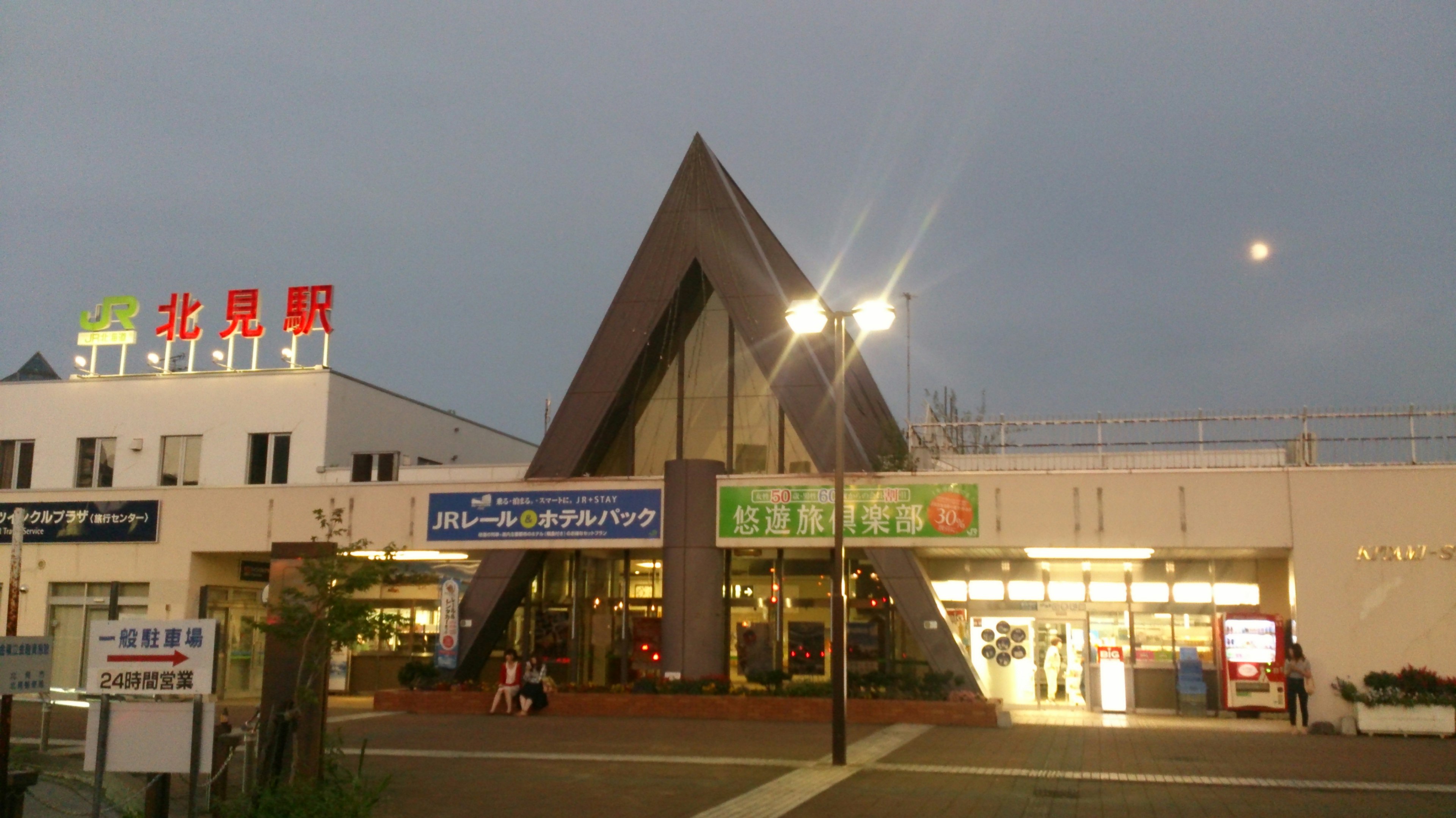 Station building with a modern triangular roof and surrounding signage