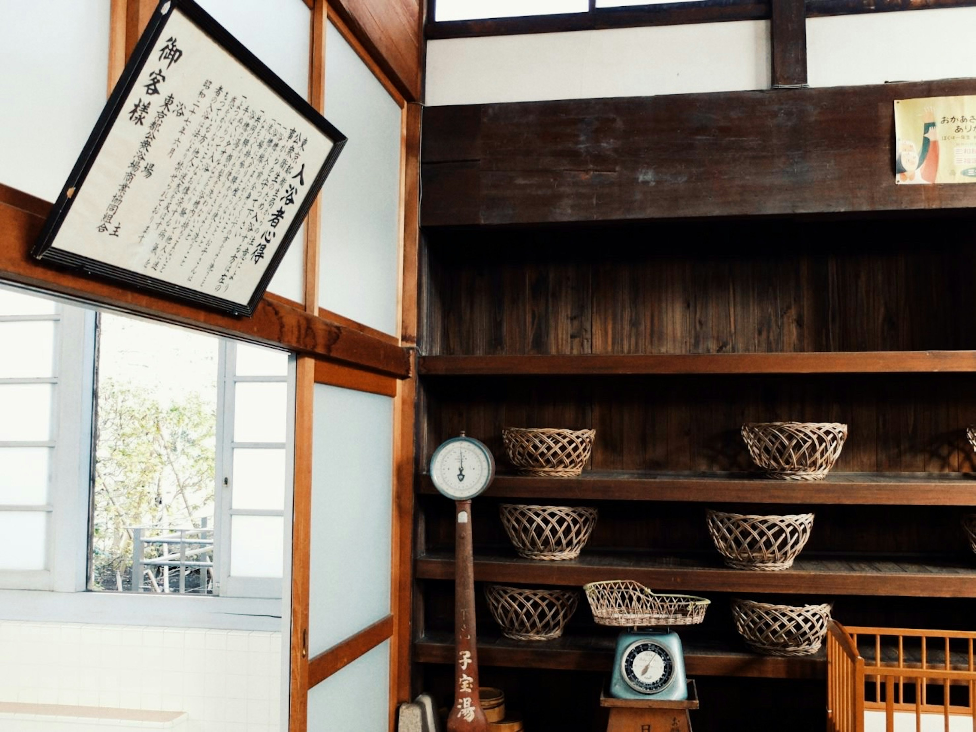 Intérieur d'une pièce japonaise traditionnelle avec des étagères en bois et des paniers, document ancien accroché au mur