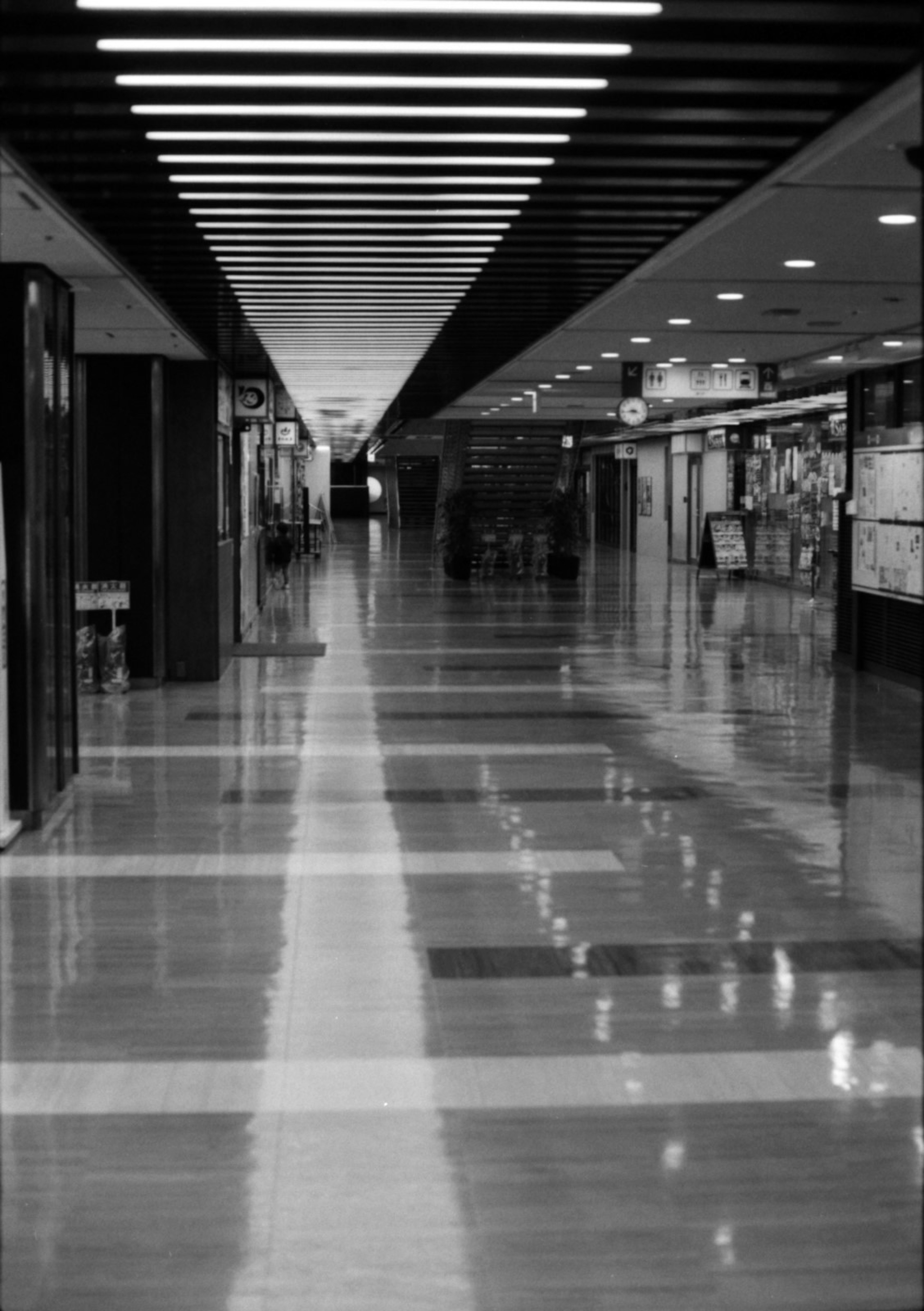 Black and white photo of a modern hallway with reflective floors