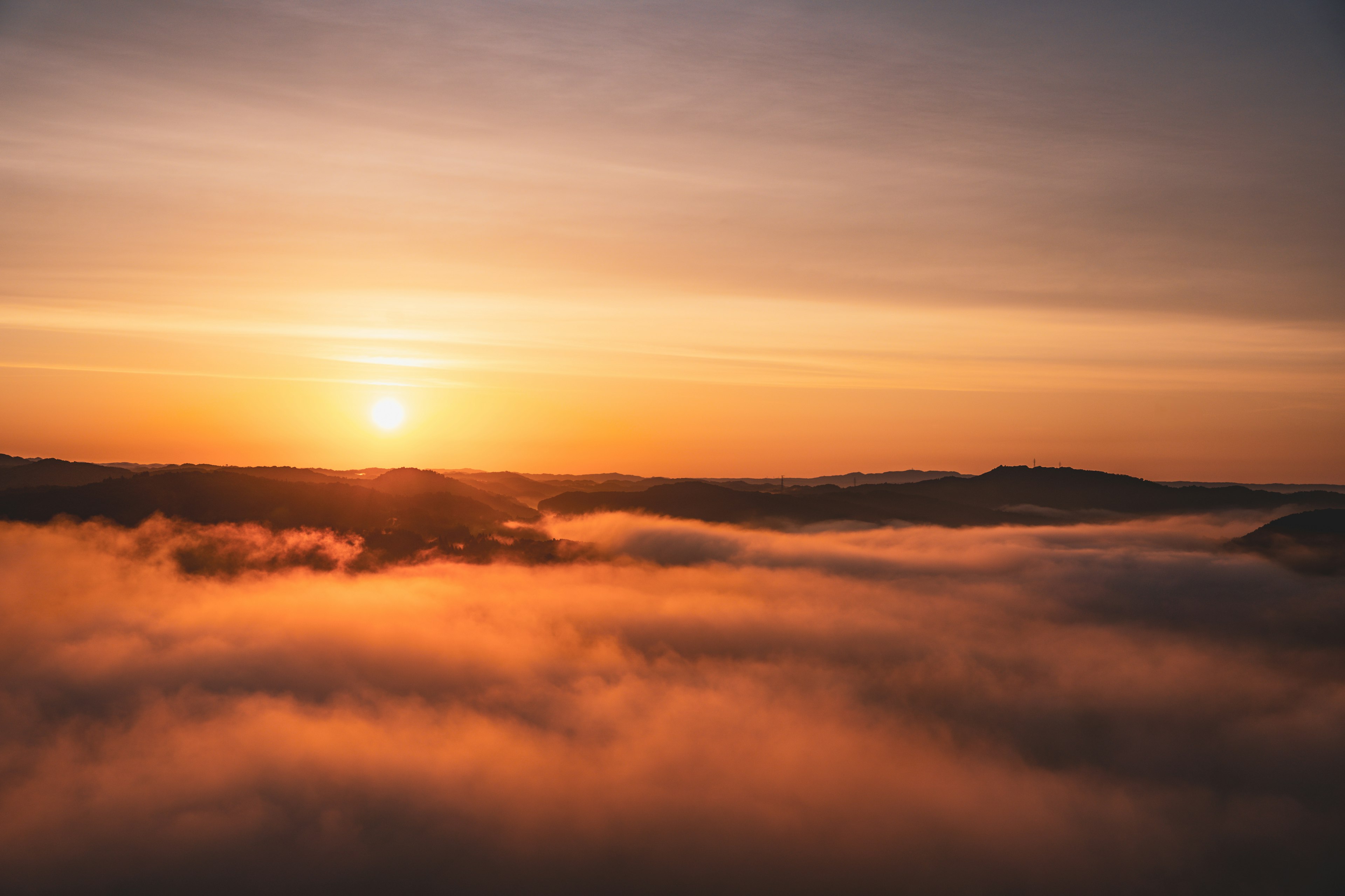 A landscape of a sea of clouds at sunrise