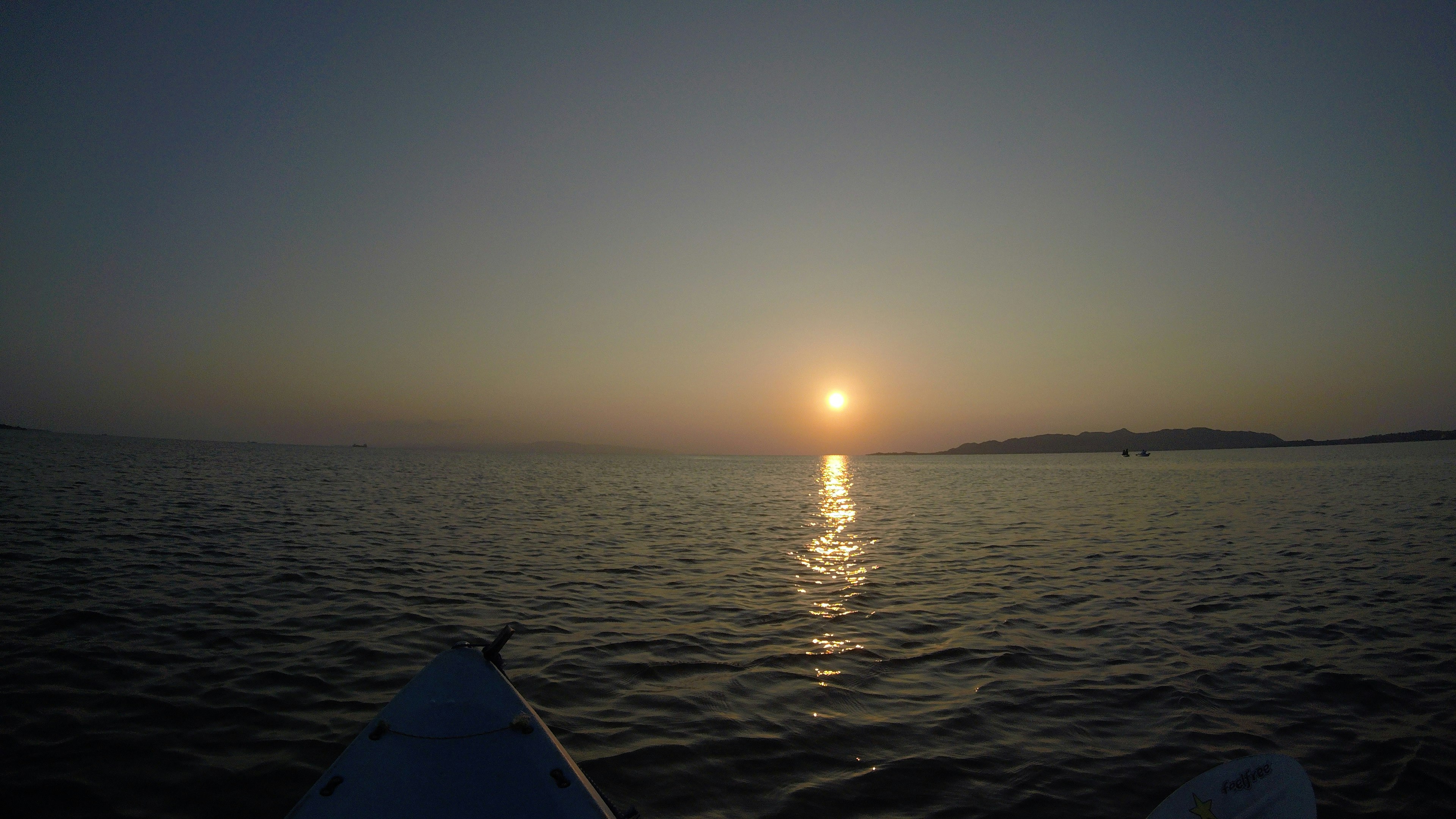 Mer calme avec un coucher de soleil et son reflet