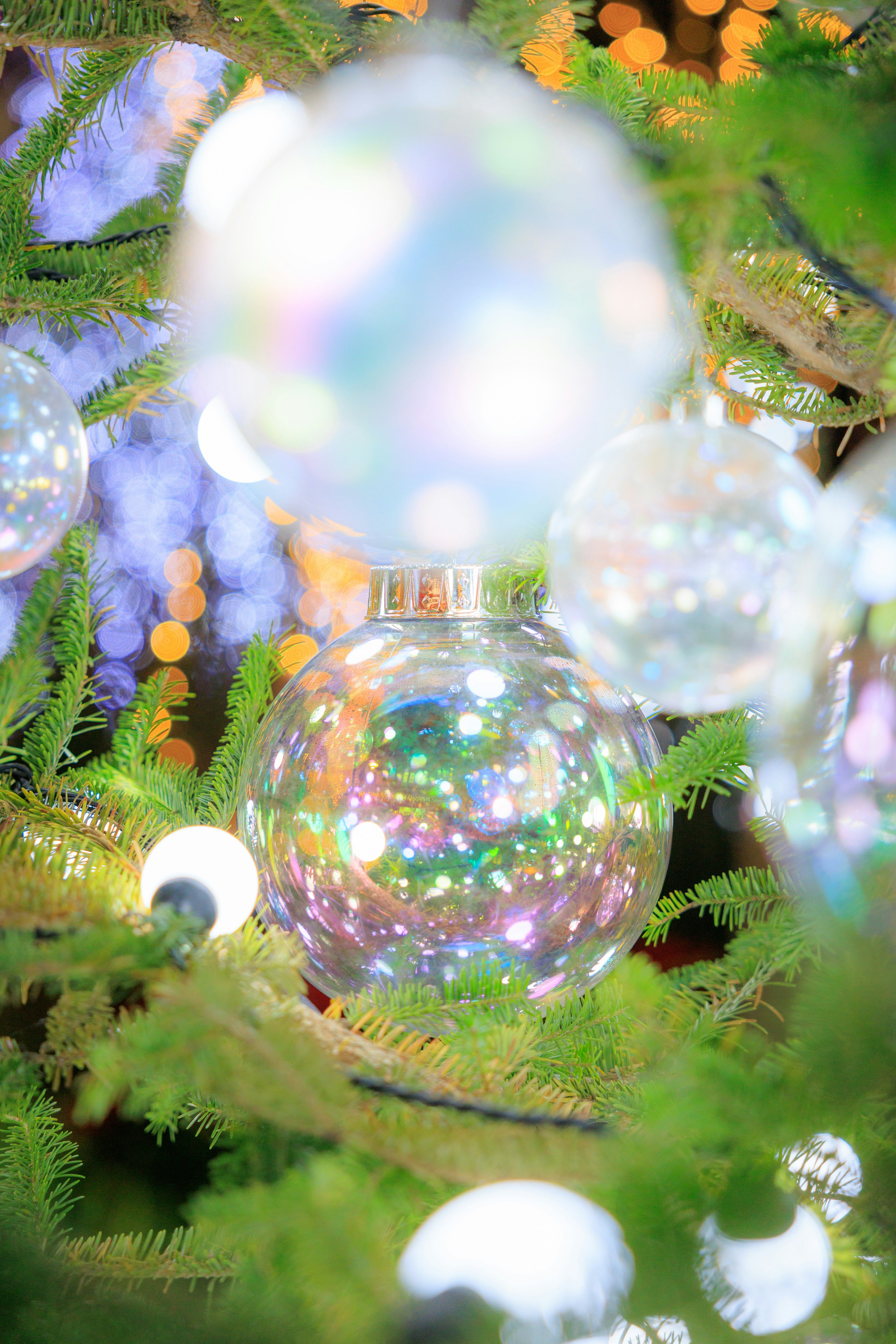 Árbol de Navidad decorado con adornos transparentes que reflejan la luz