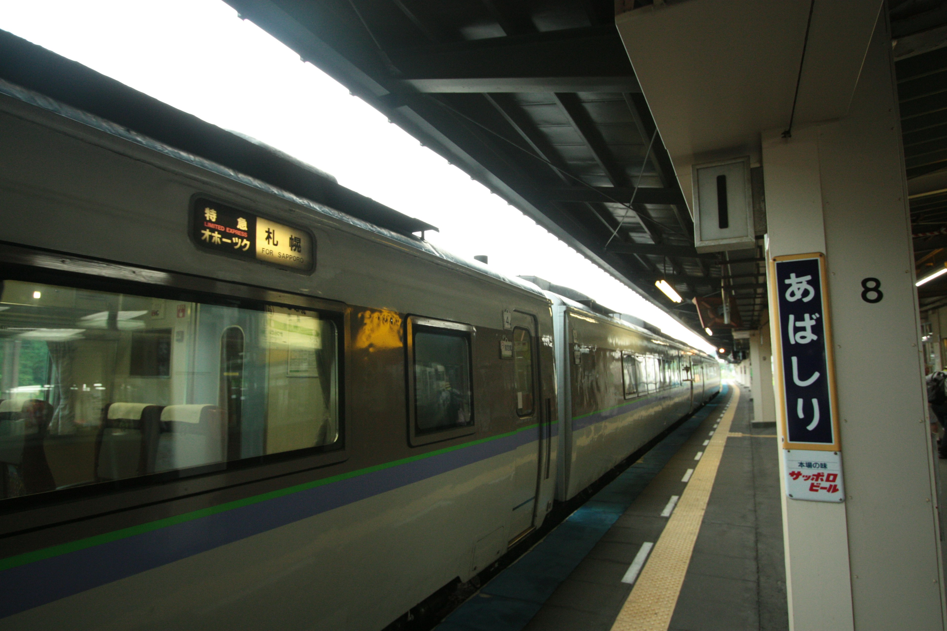 Train à un quai avec signalisation de la station