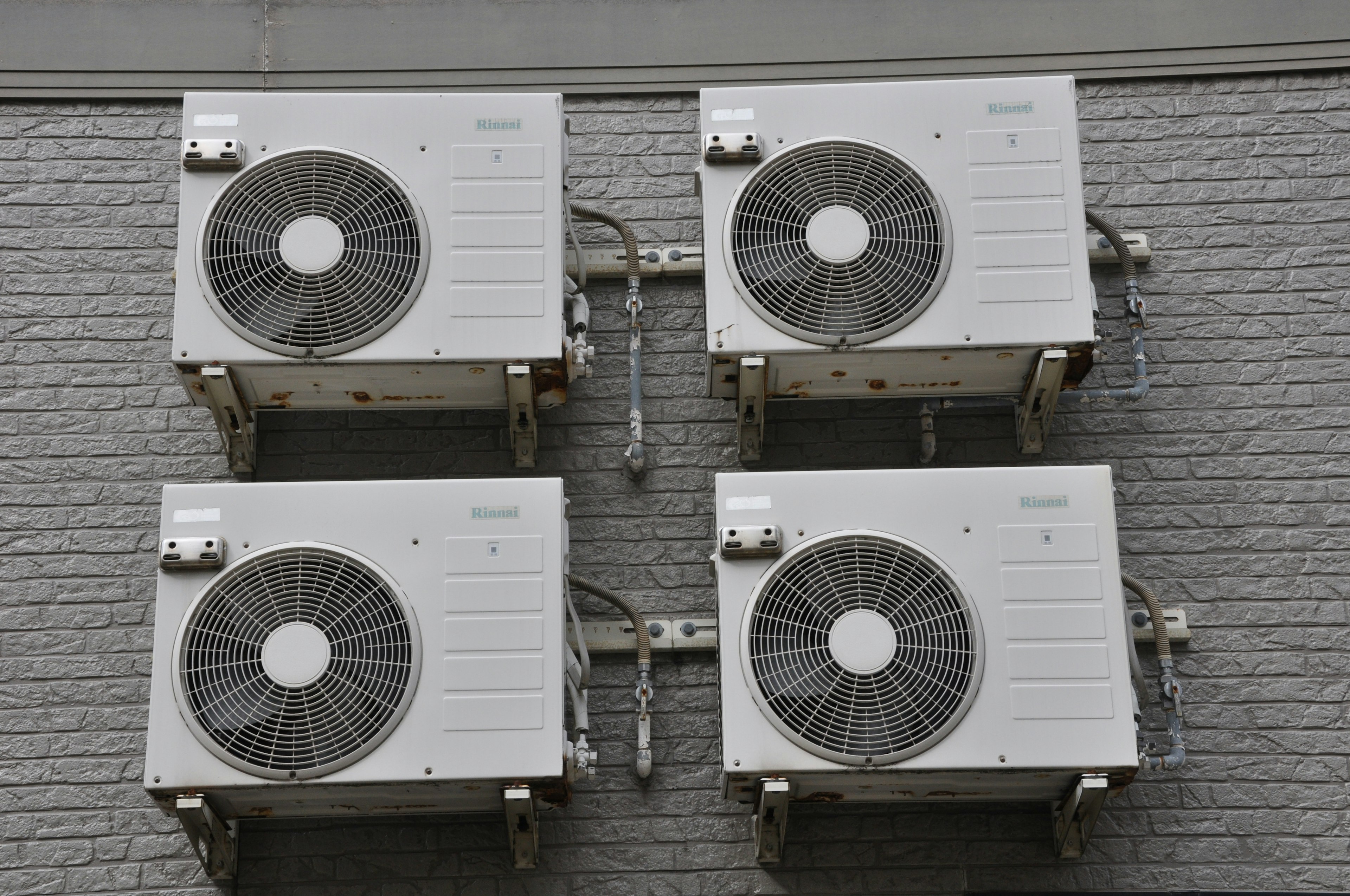 Four air conditioning units mounted on a wall