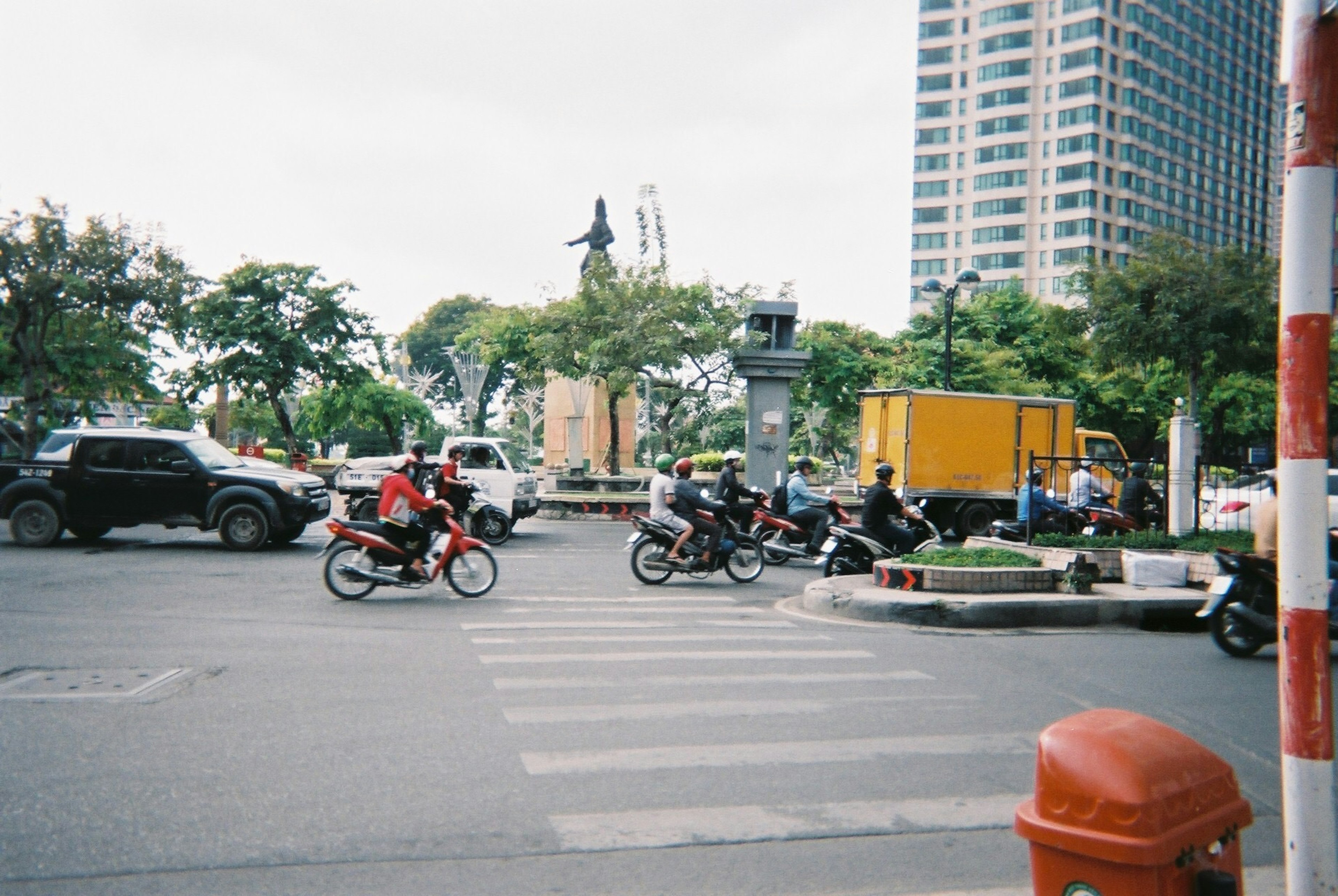 街角的交通场景，摩托车和汽车穿过交叉口