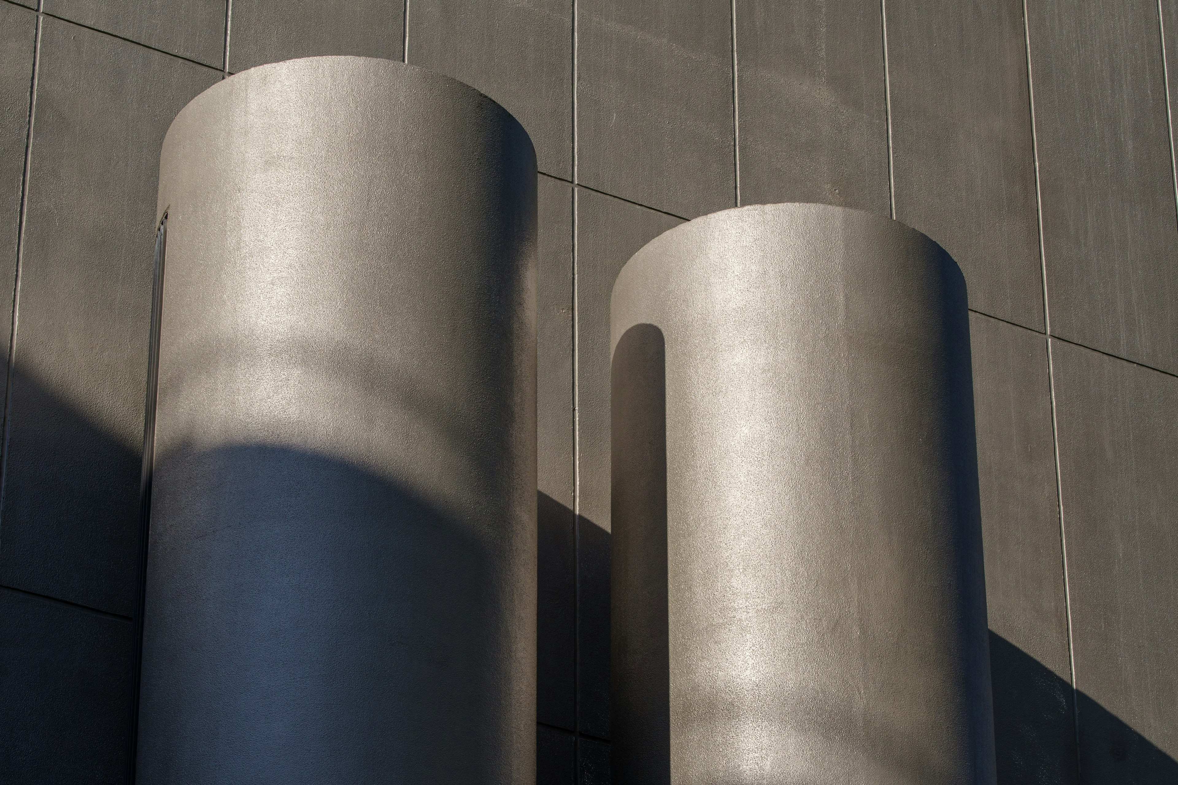 Two large concrete cylinders on a modern building exterior