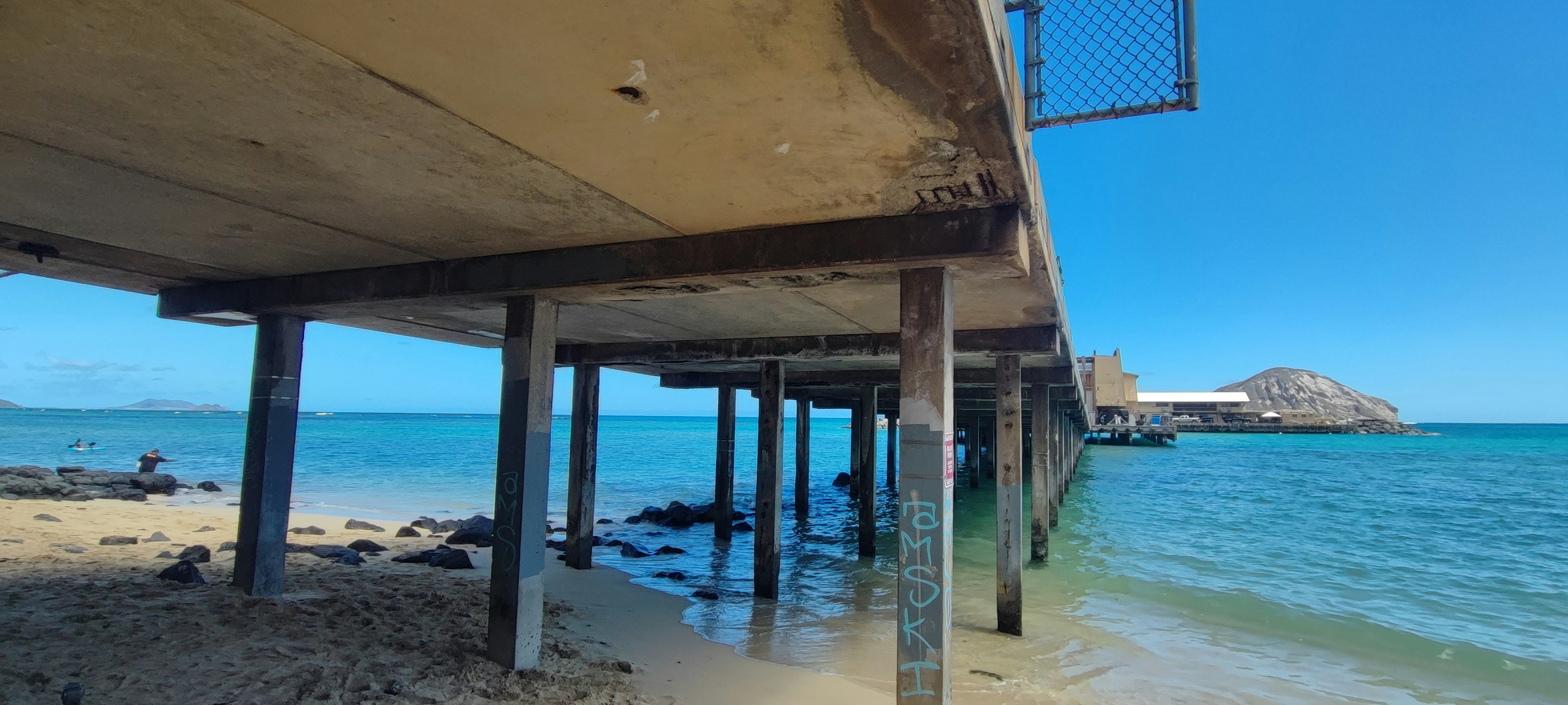 Vue depuis sous un quai en béton s'étendant dans la mer