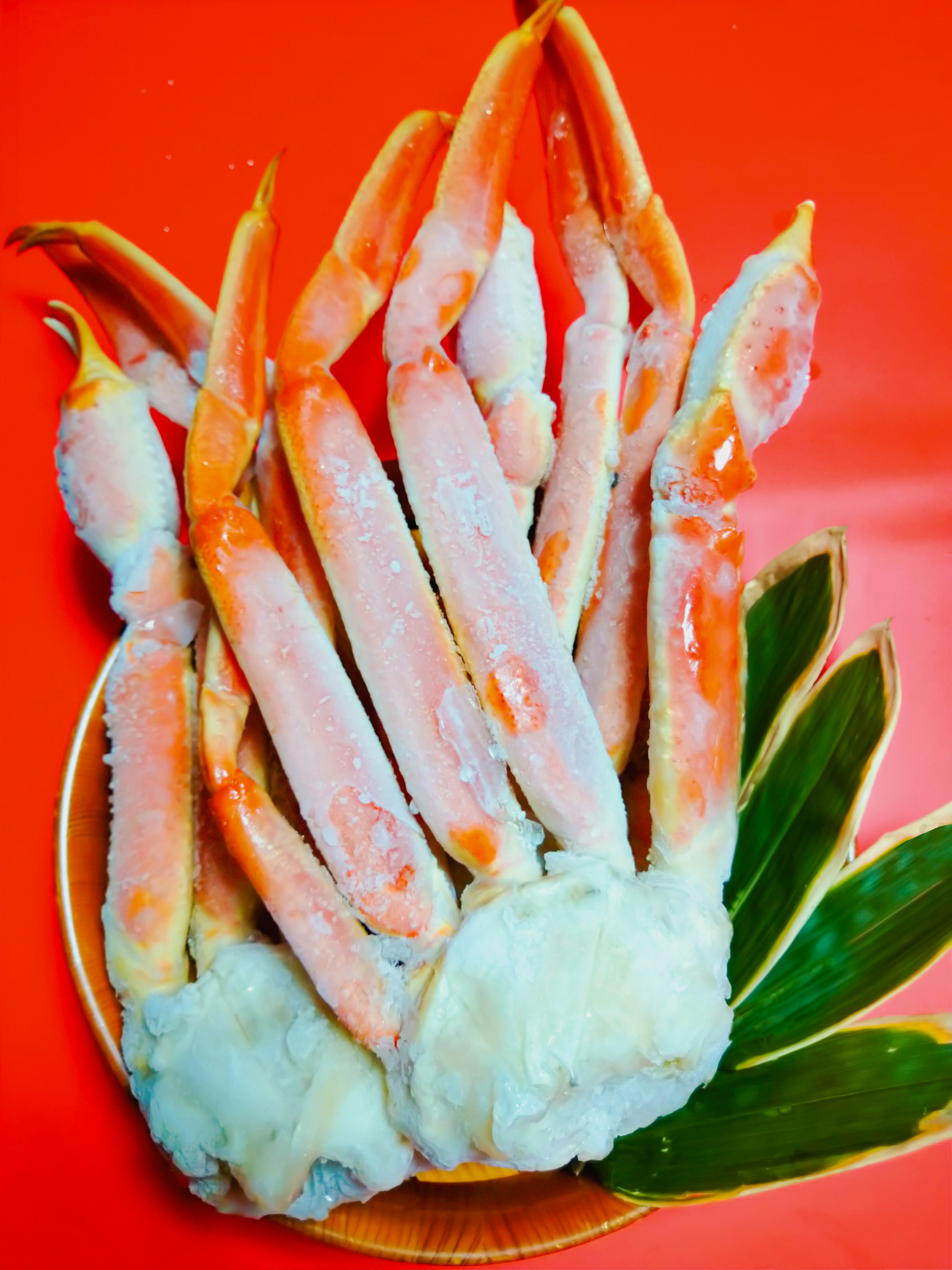 Crab legs and meat arranged on a vibrant red background