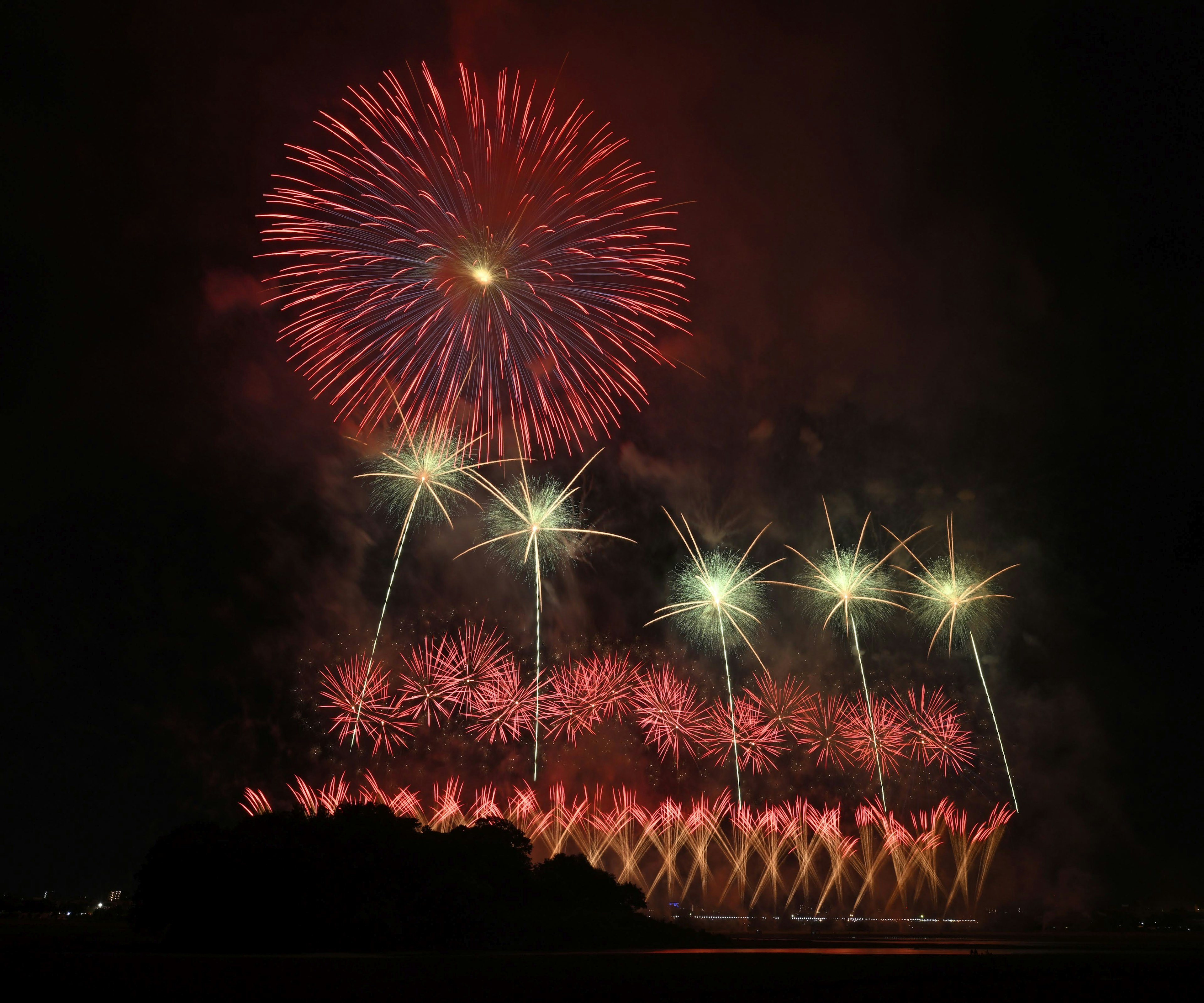 Magnifico spettacolo di fuochi d'artificio nel cielo notturno con colori rossi e bianchi e motivi impressionanti