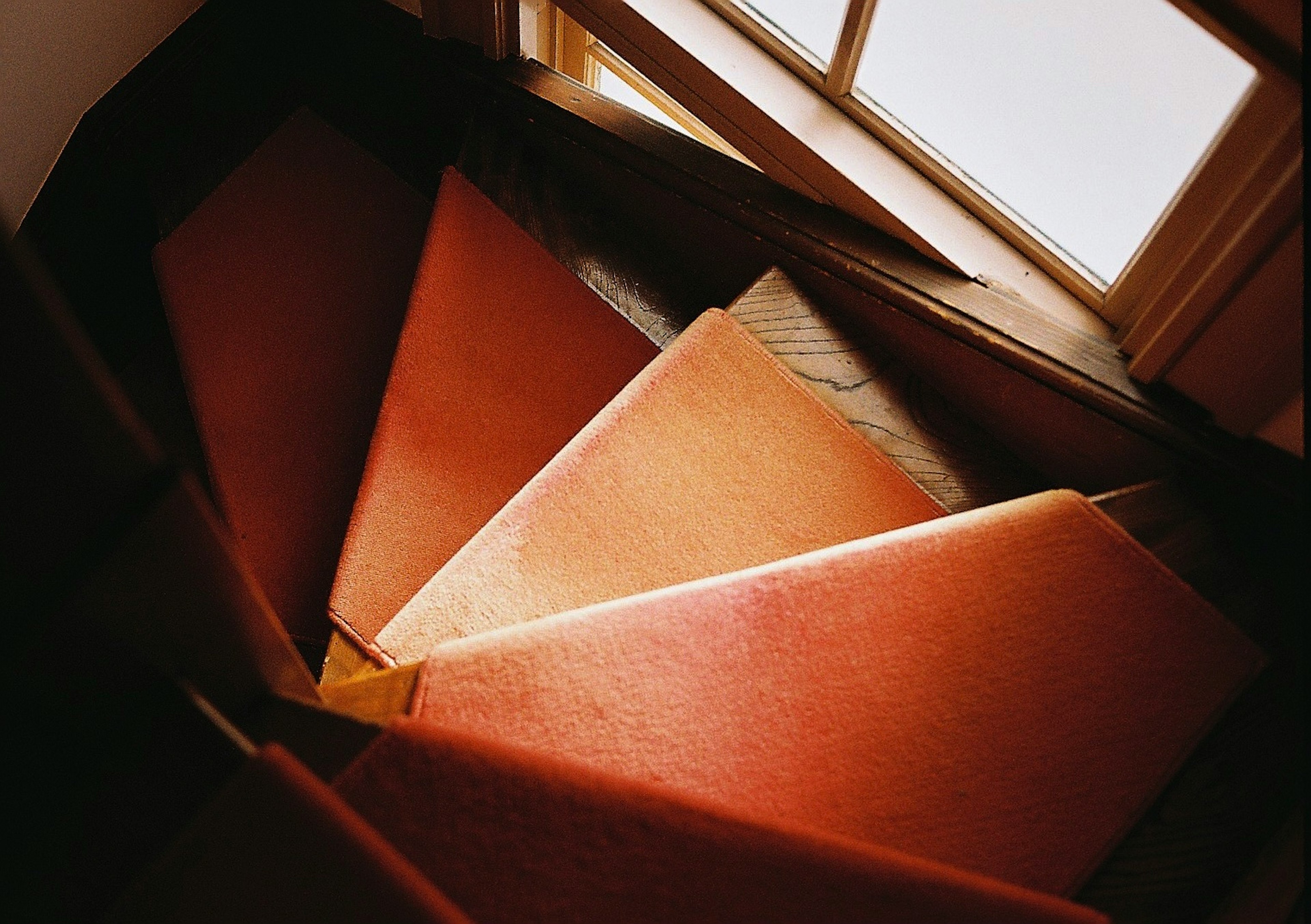 View of a spiral staircase with red carpet steps