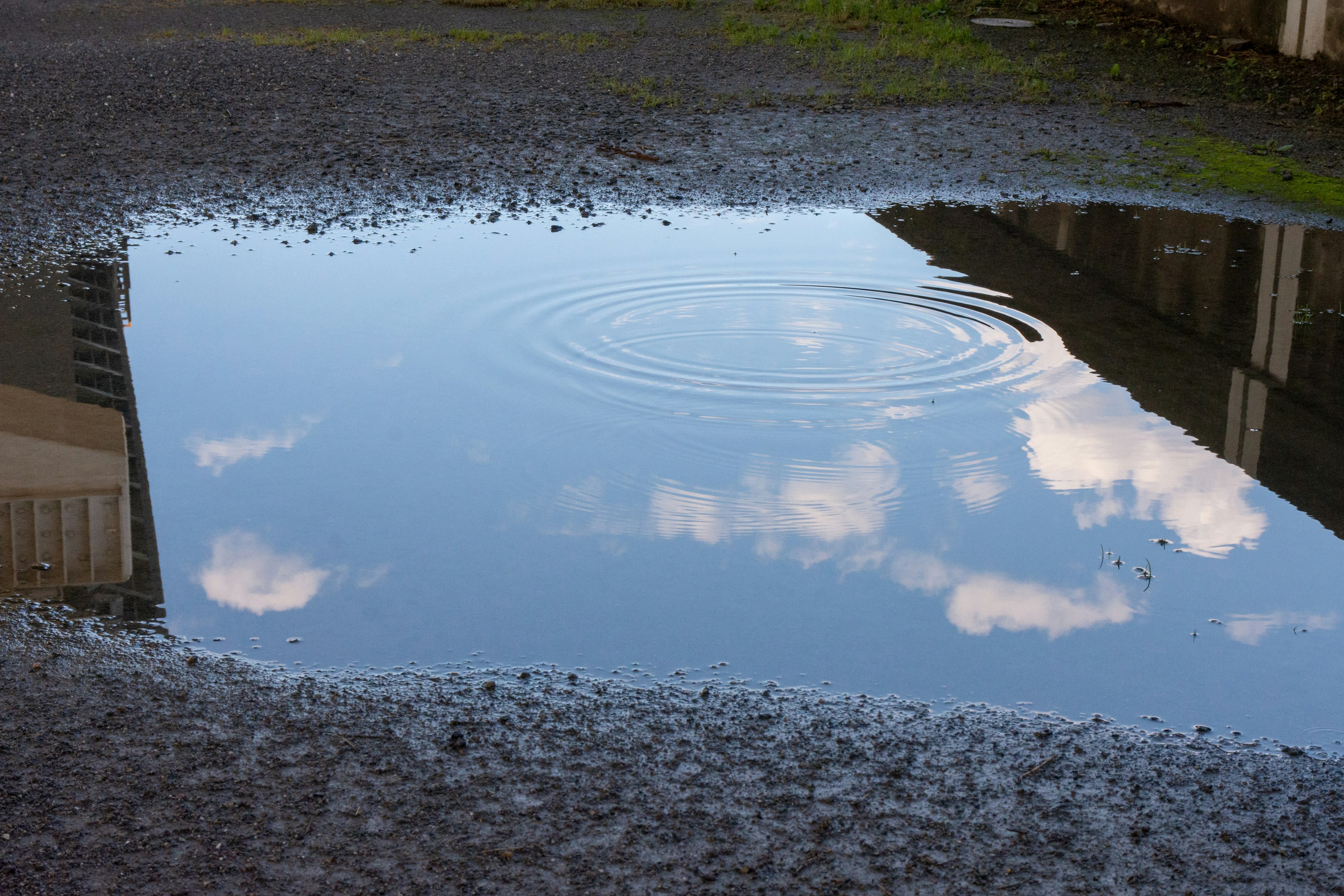 Reflexion des Himmels und der Wolken in einer Pfütze