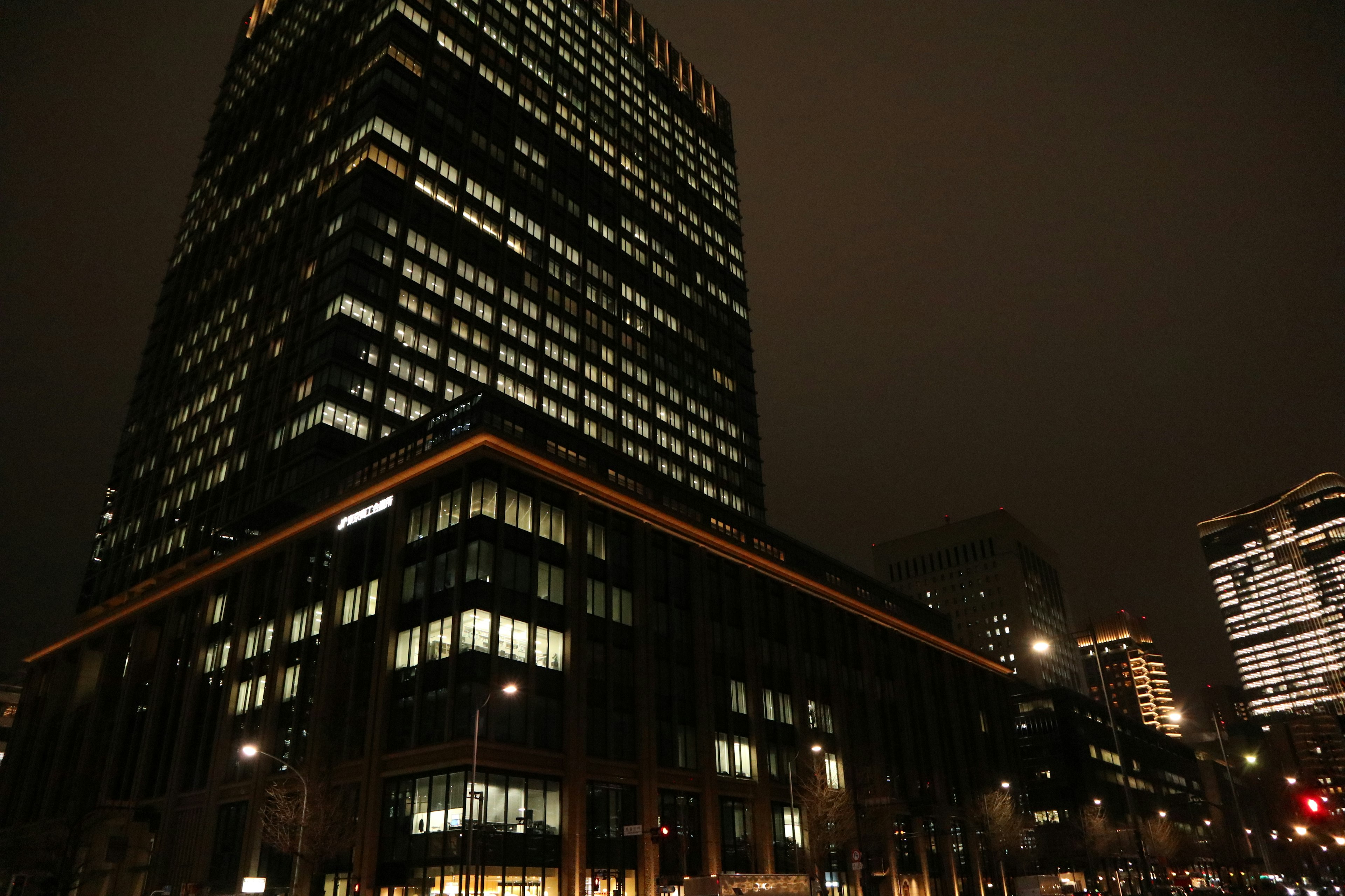 Photo of a skyscraper towering in a night cityscape with illuminated windows