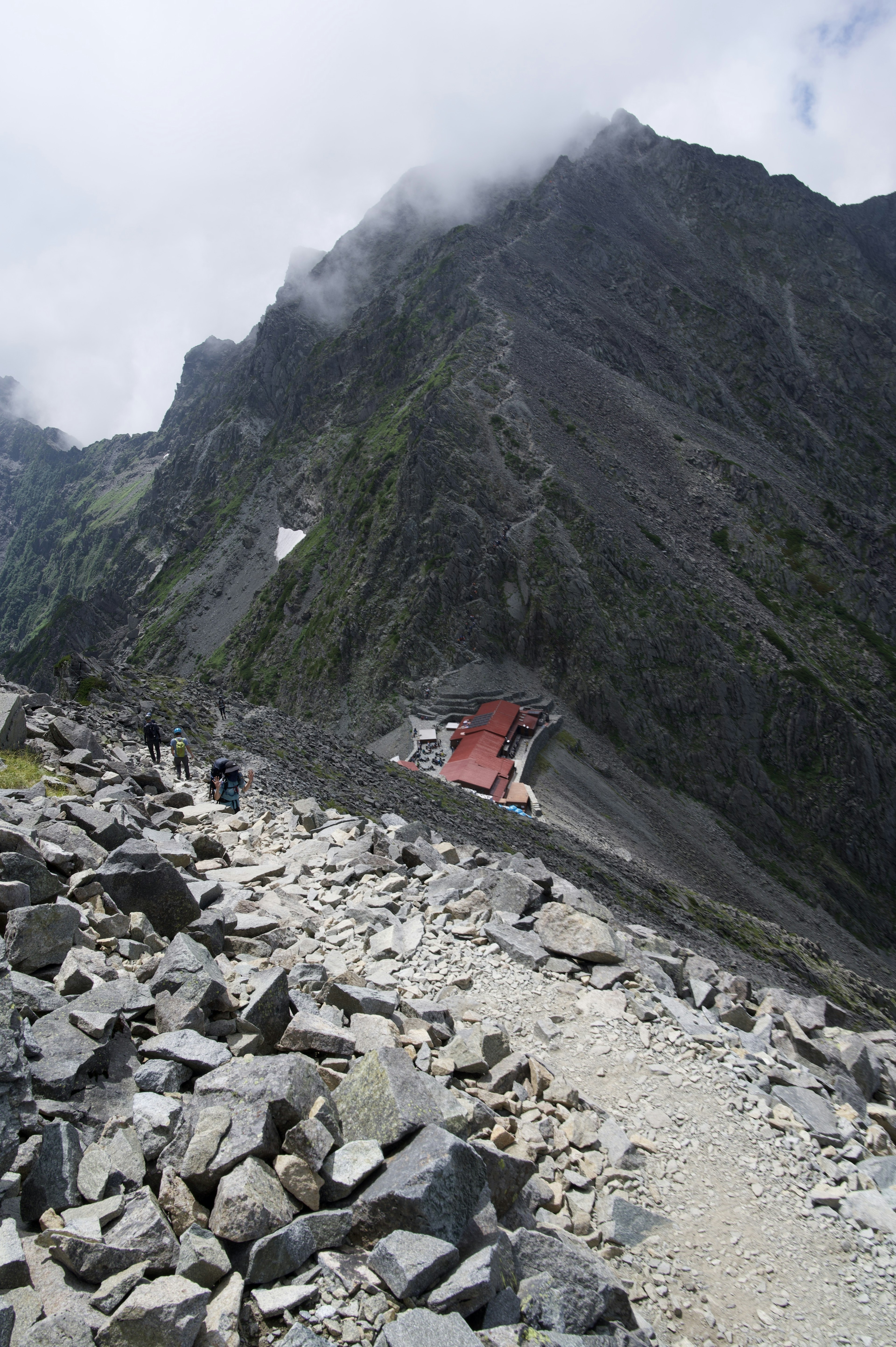 山道を歩く人々と岩だらけの風景の写真