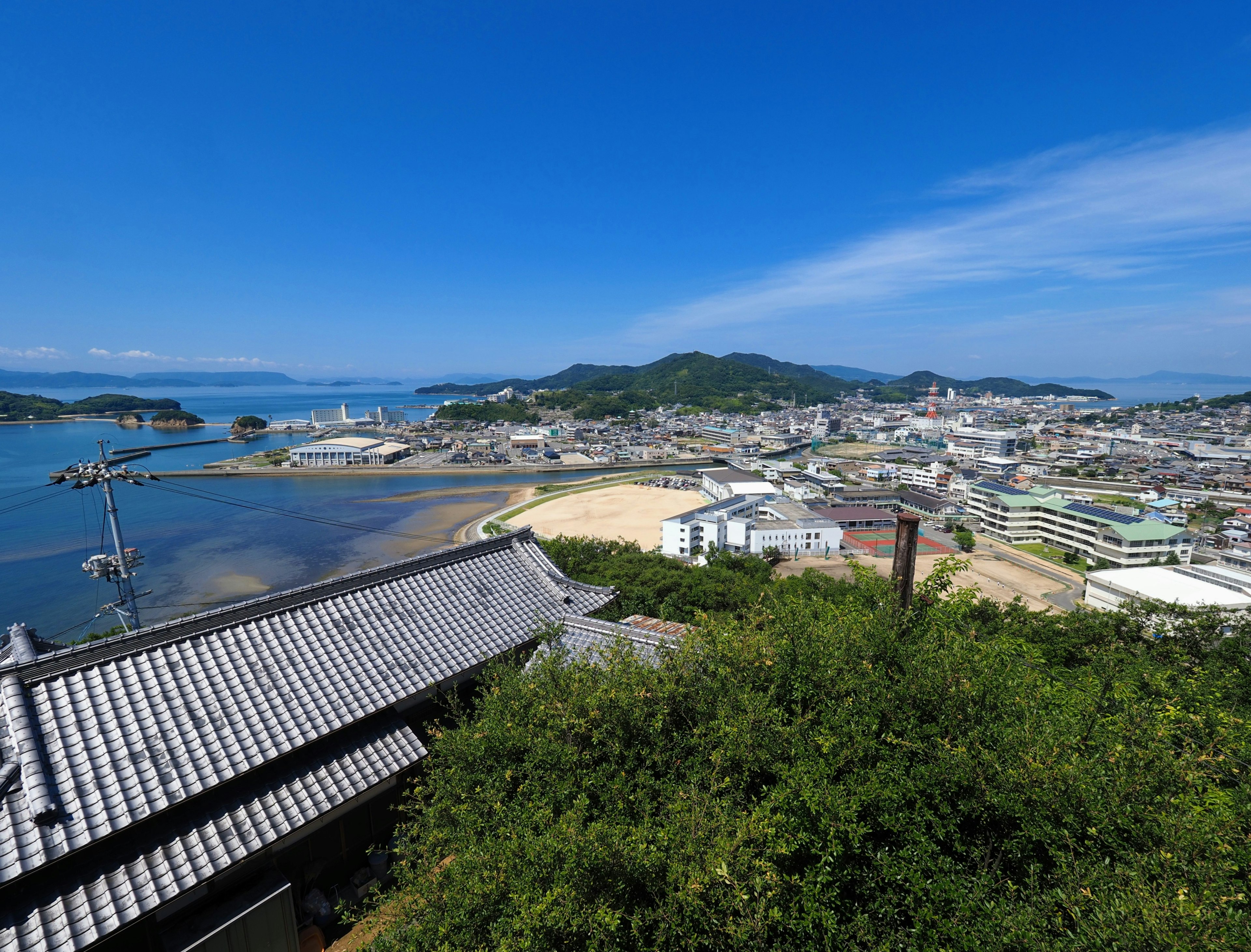 Panoramic view of coastline and town under blue sky