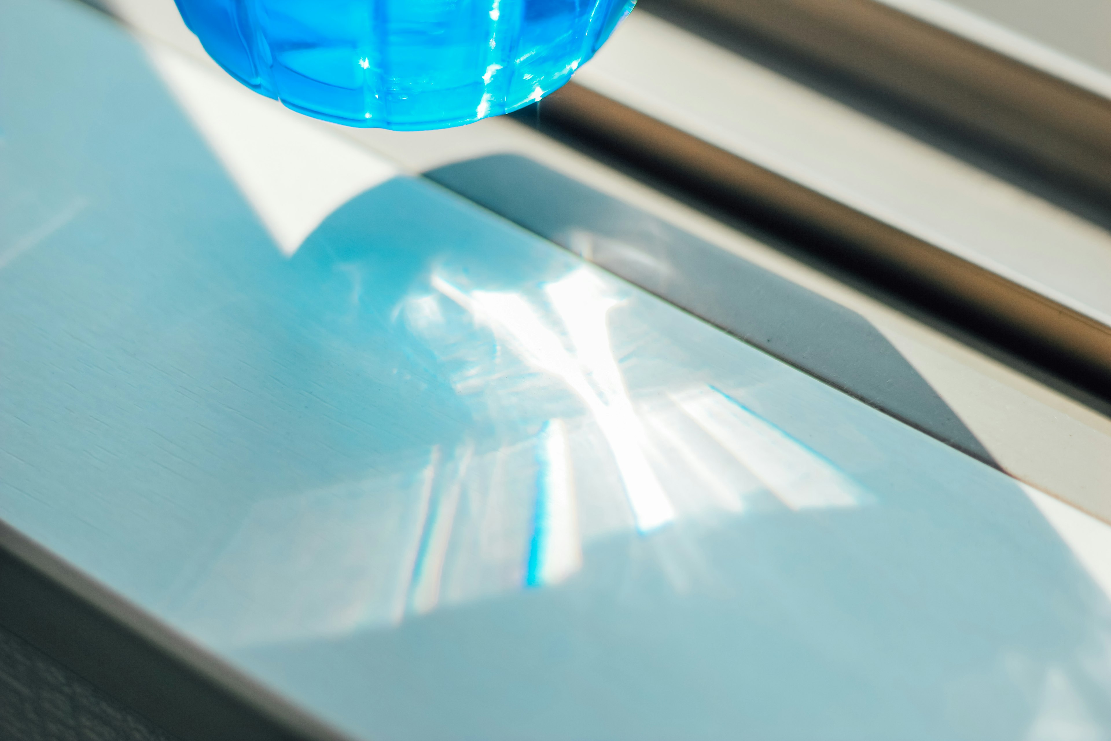 A blue bottle reflecting light on a surface