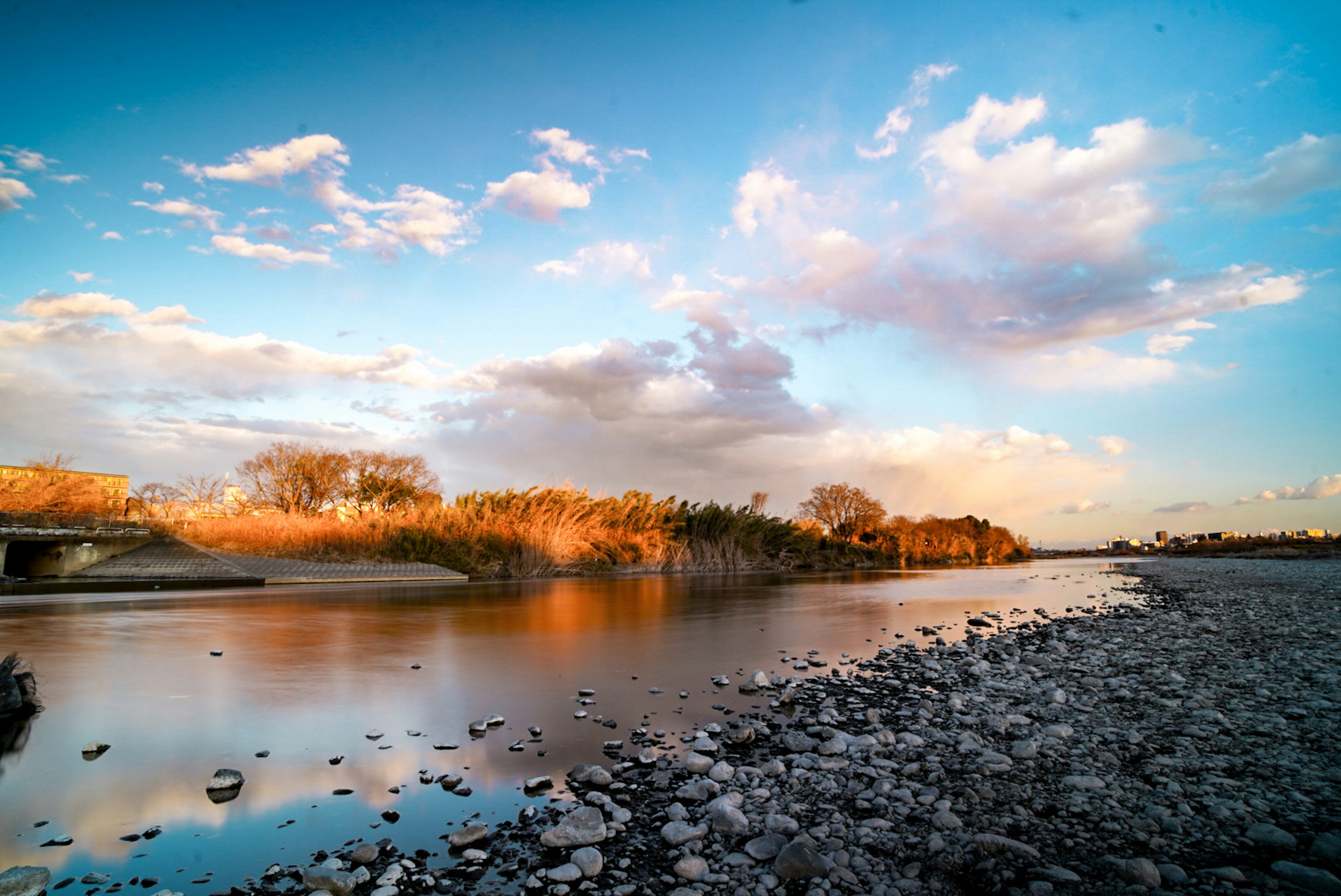 Serene river landscape with blue sky and white clouds