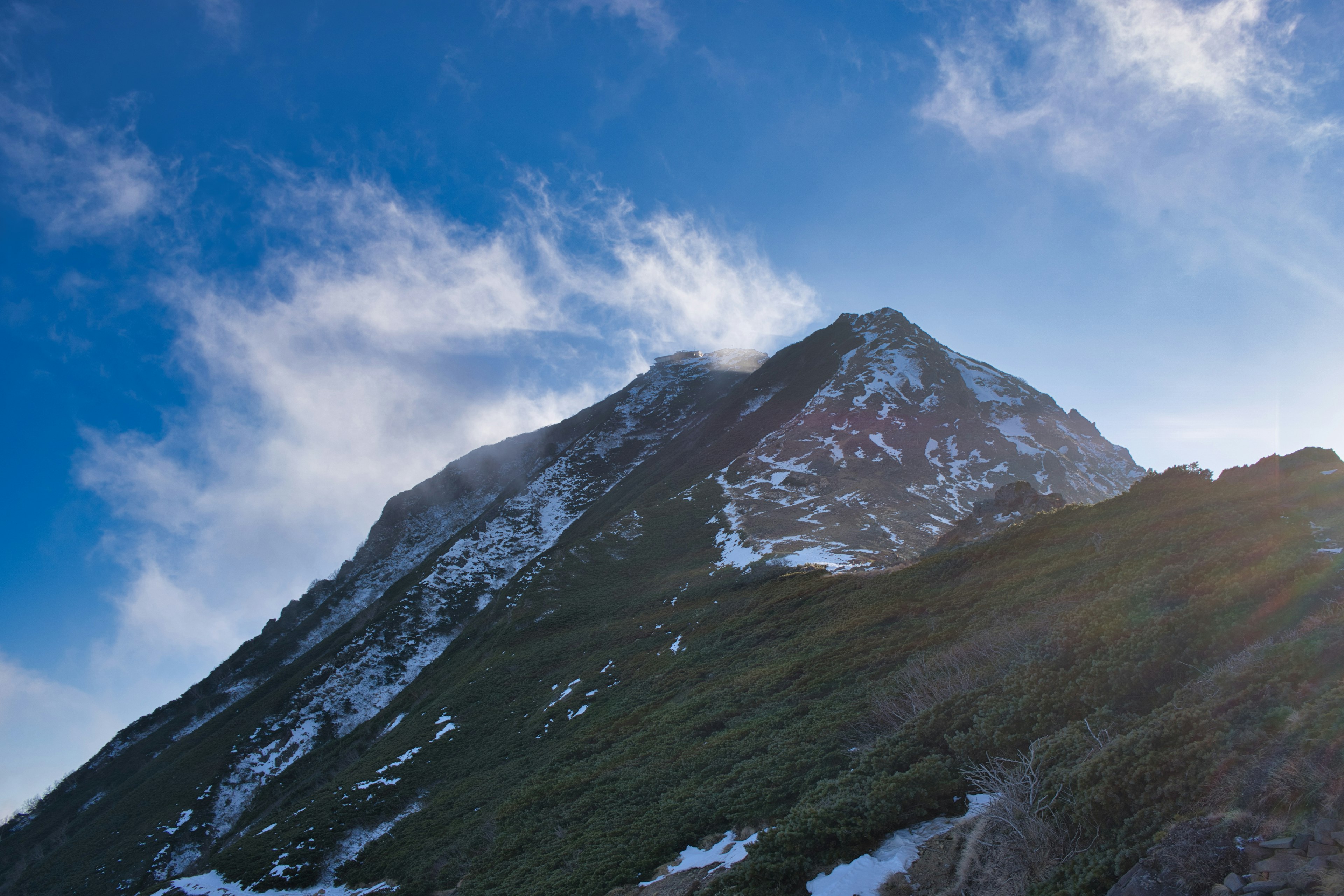 Snow-covered mountain peak under a blue sky