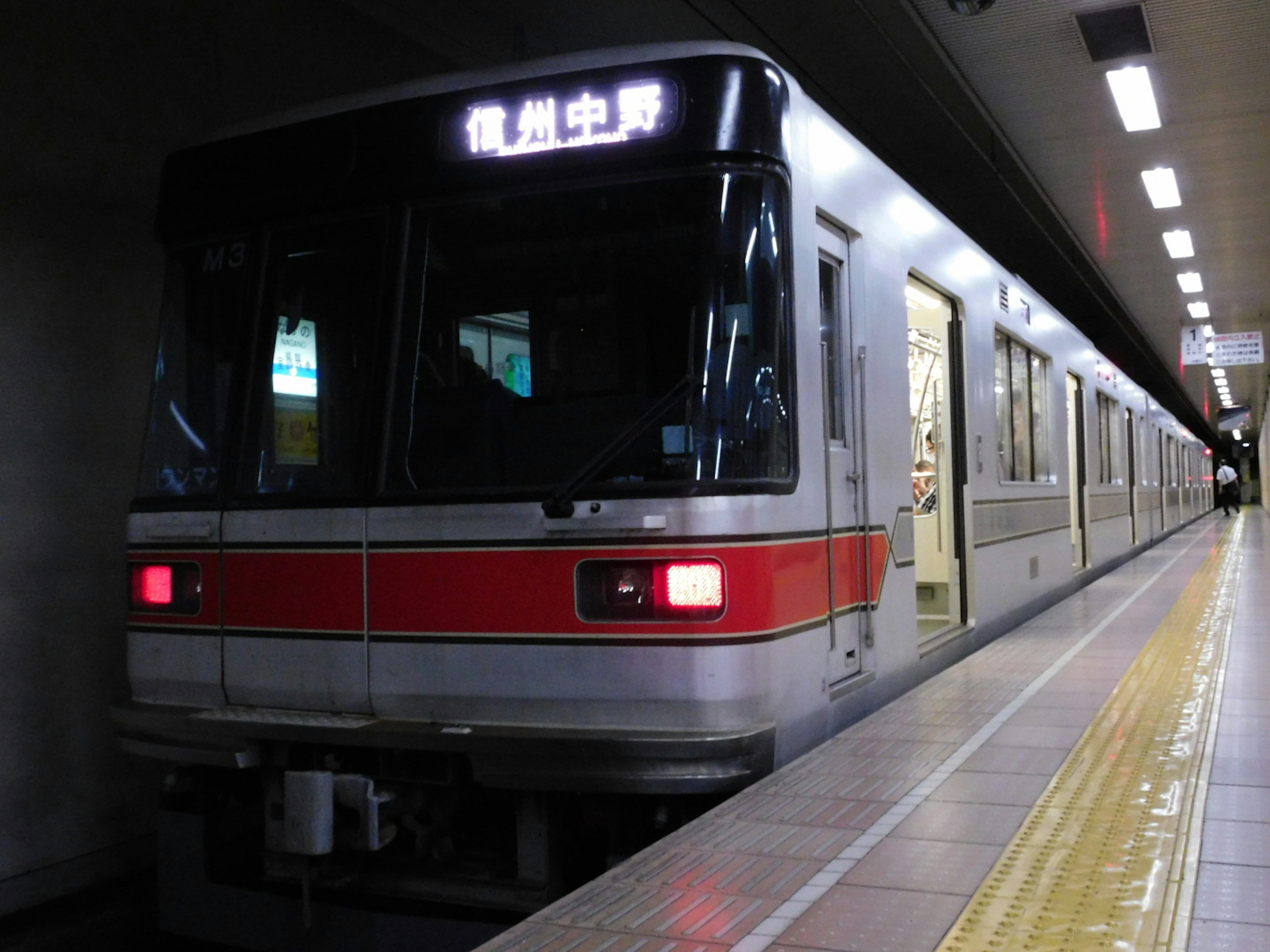 Un train de métro à une station avec une plateforme et un éclairage visibles