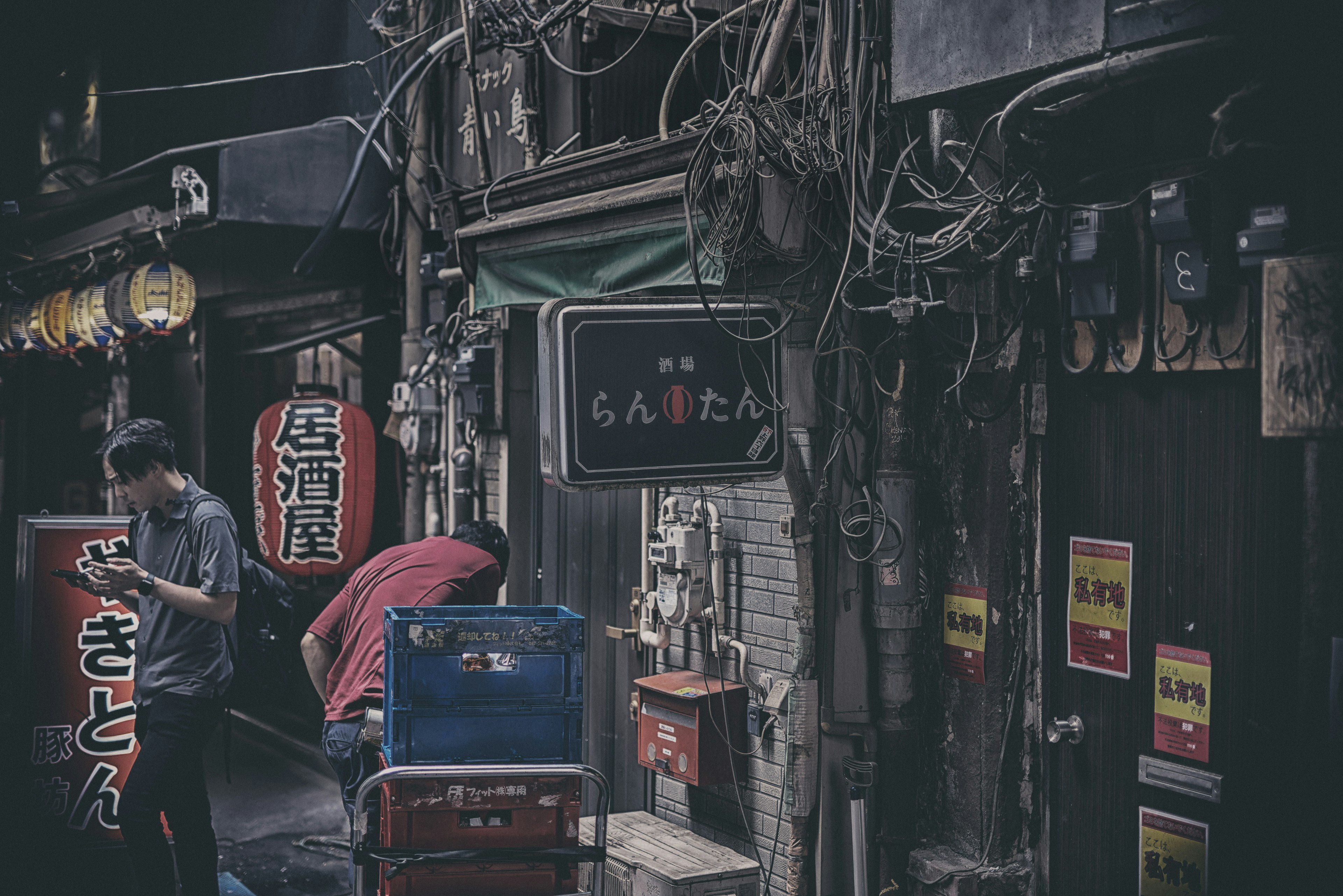 Ruelle étroite avec des enseignes de restaurants traditionnels et des personnes