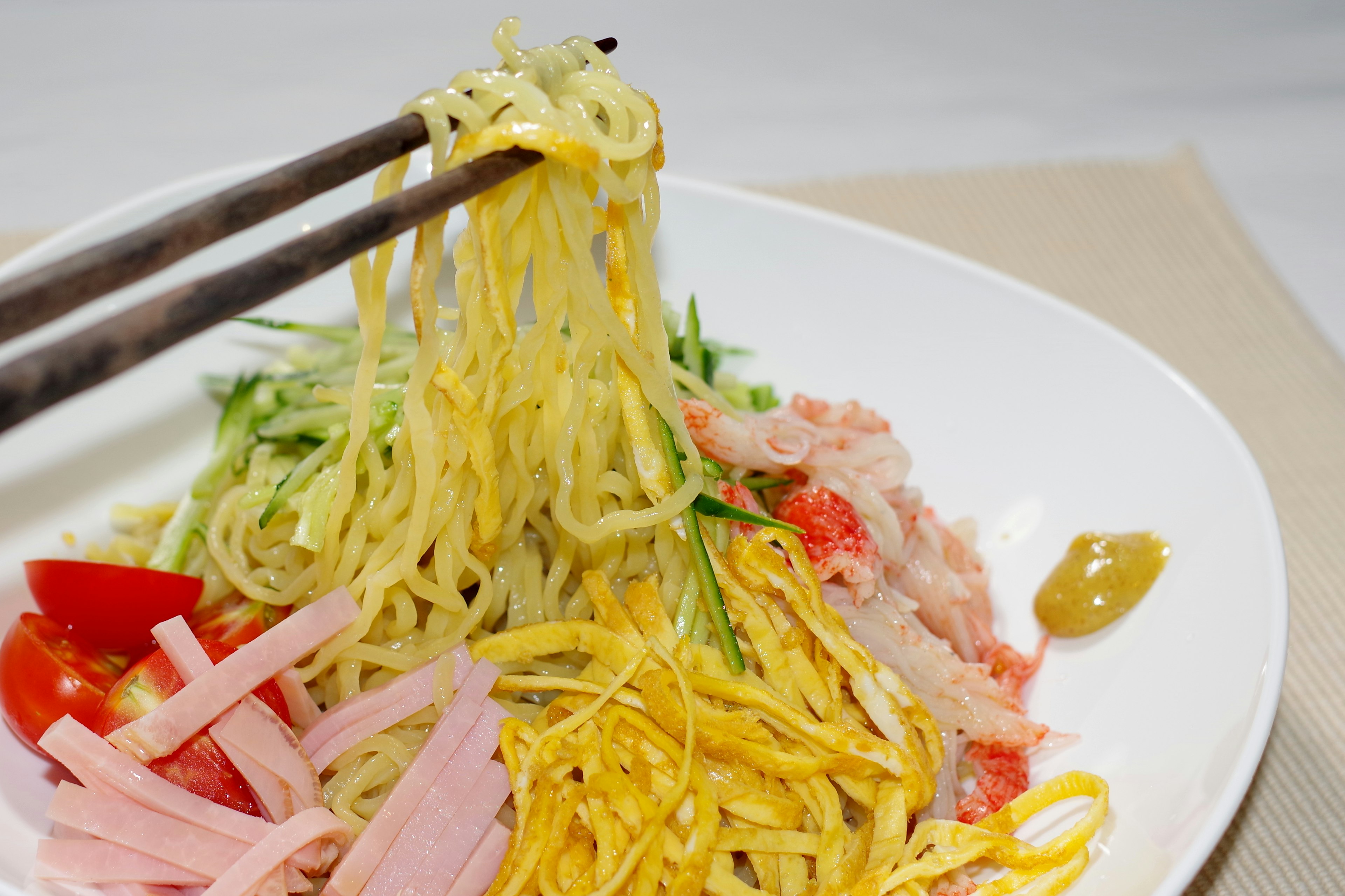 Plate of cold Chinese noodles topped with colorful ingredients