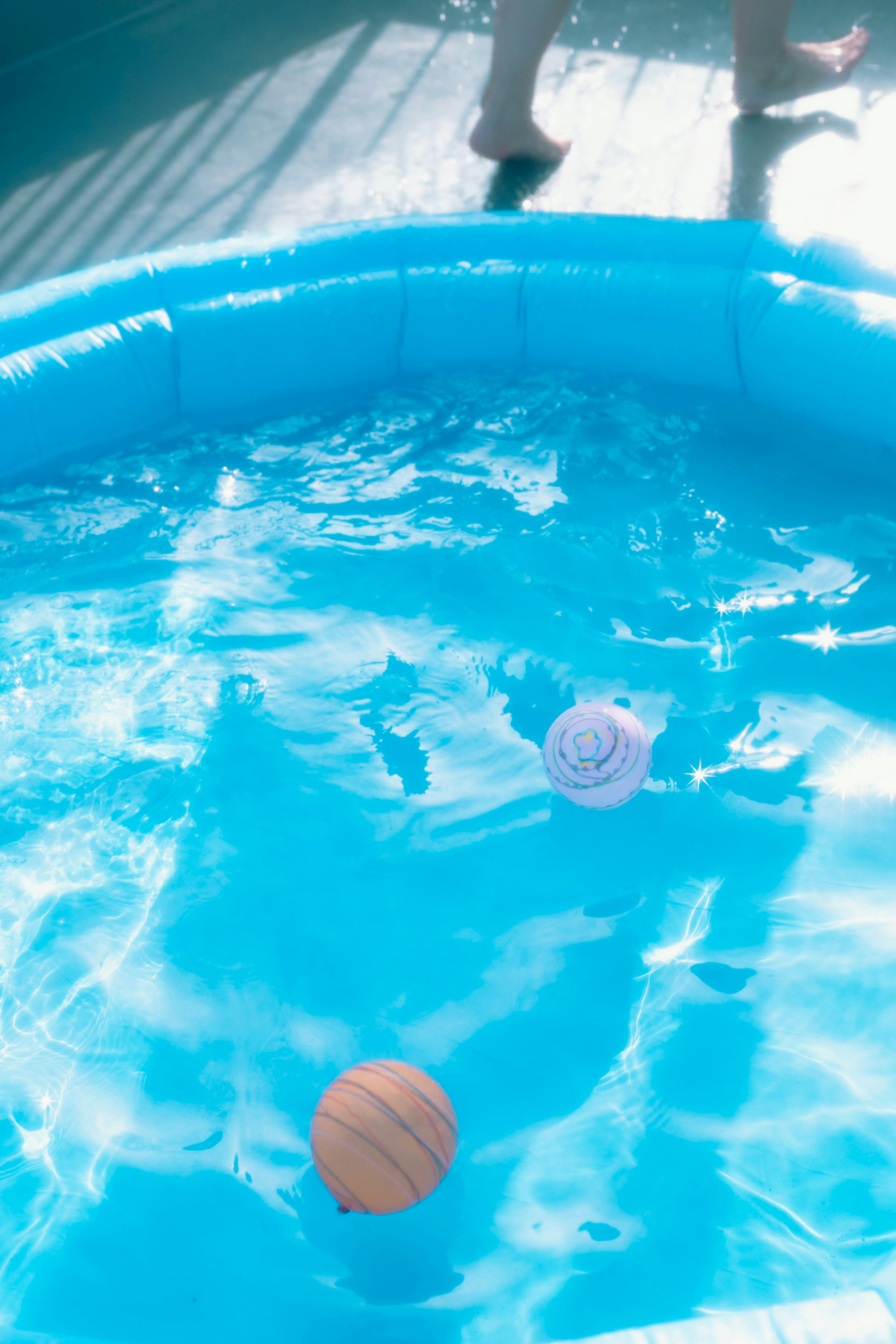 Palle di legno e viola che galleggiano in una piscina blu