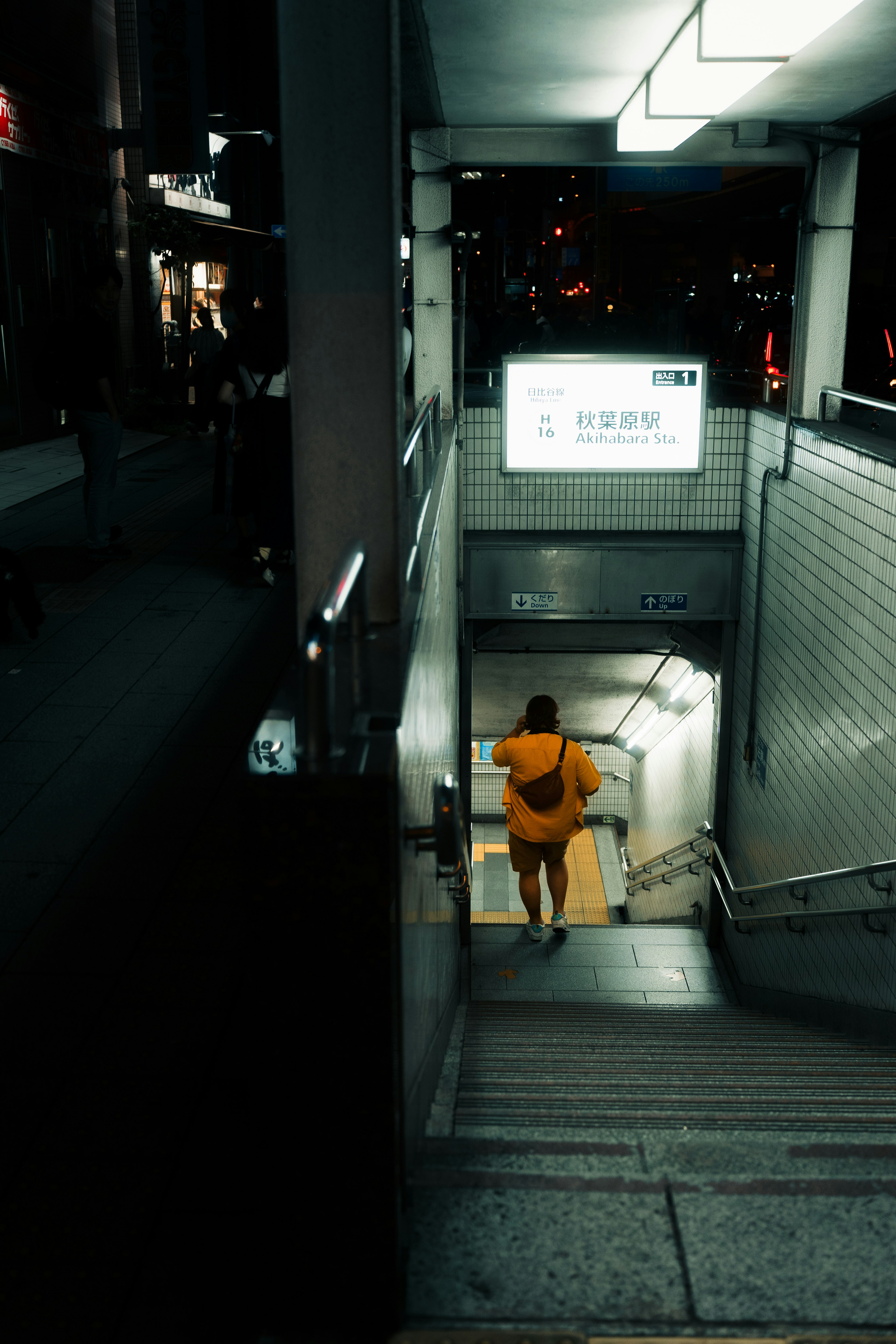 Person descending stairs at night city scene visible