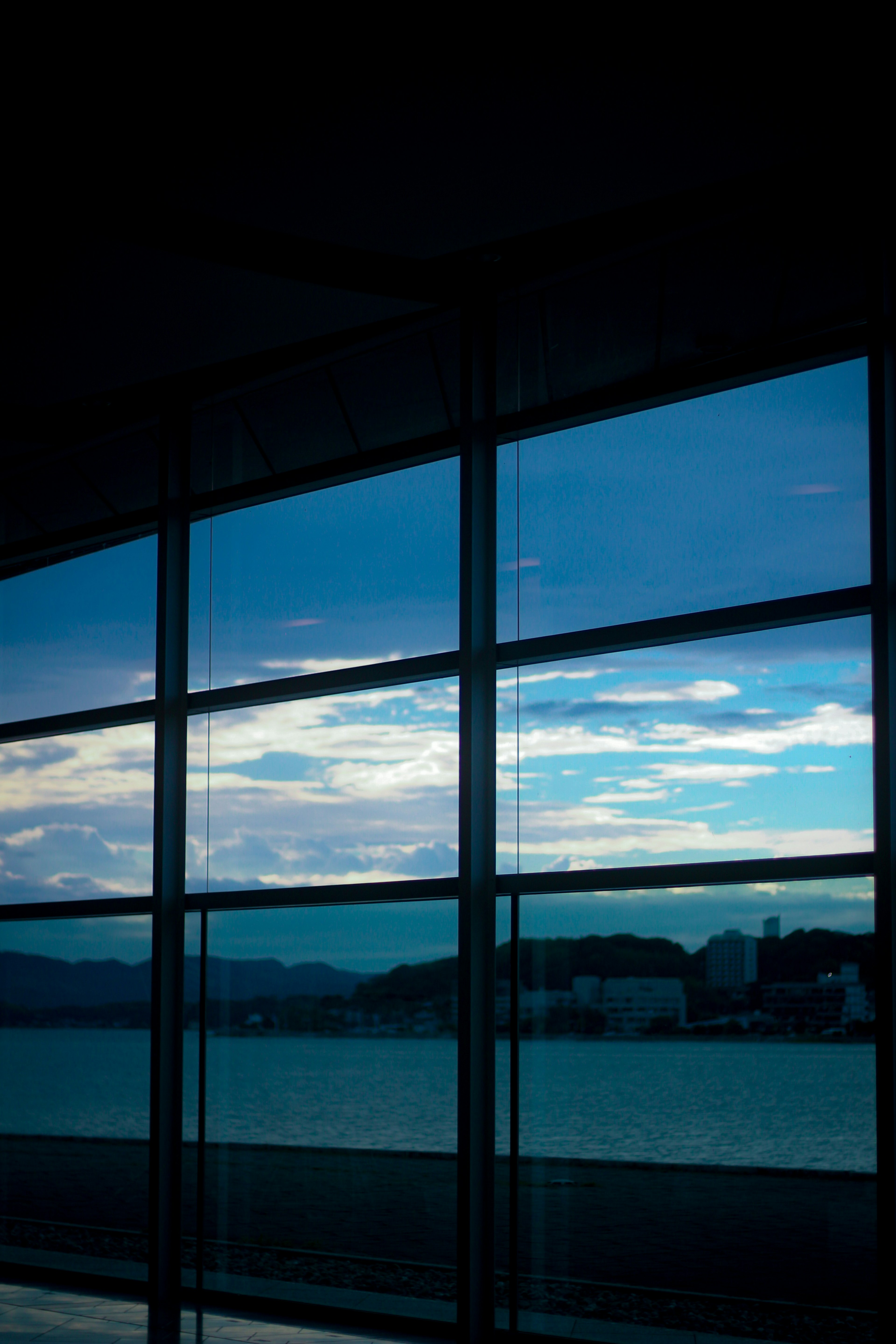 Großes Fenster, das blauen Himmel und Wolken reflektiert