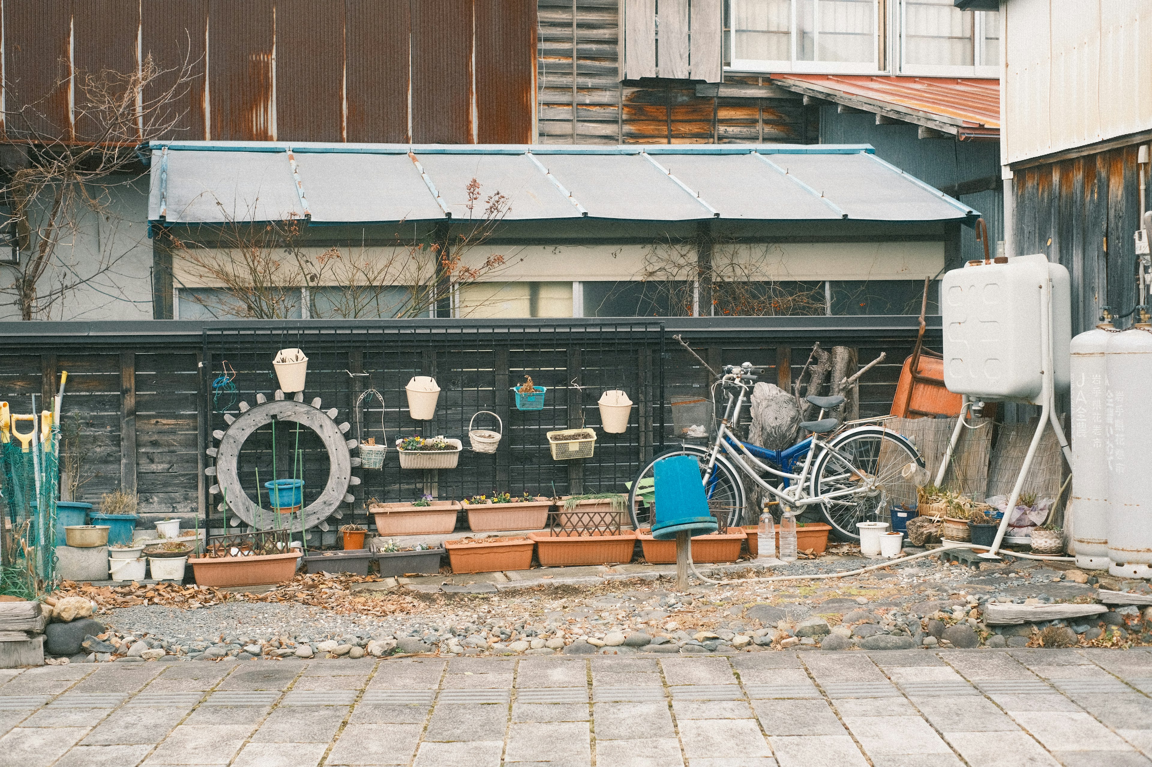 古い家の外観に並ぶ自転車や植木鉢のある風景