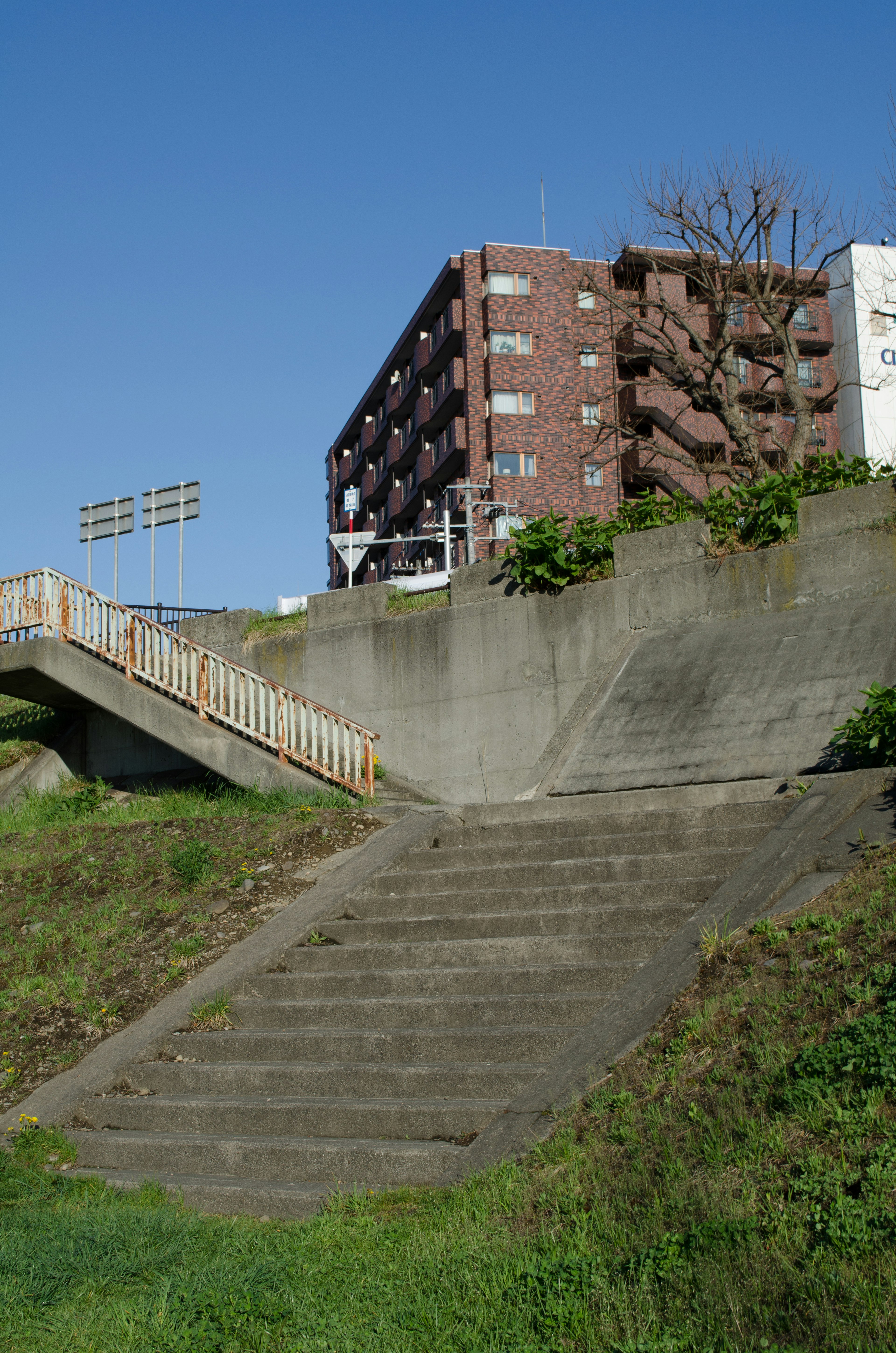 Escalier menant à un bâtiment résidentiel sous un ciel bleu clair