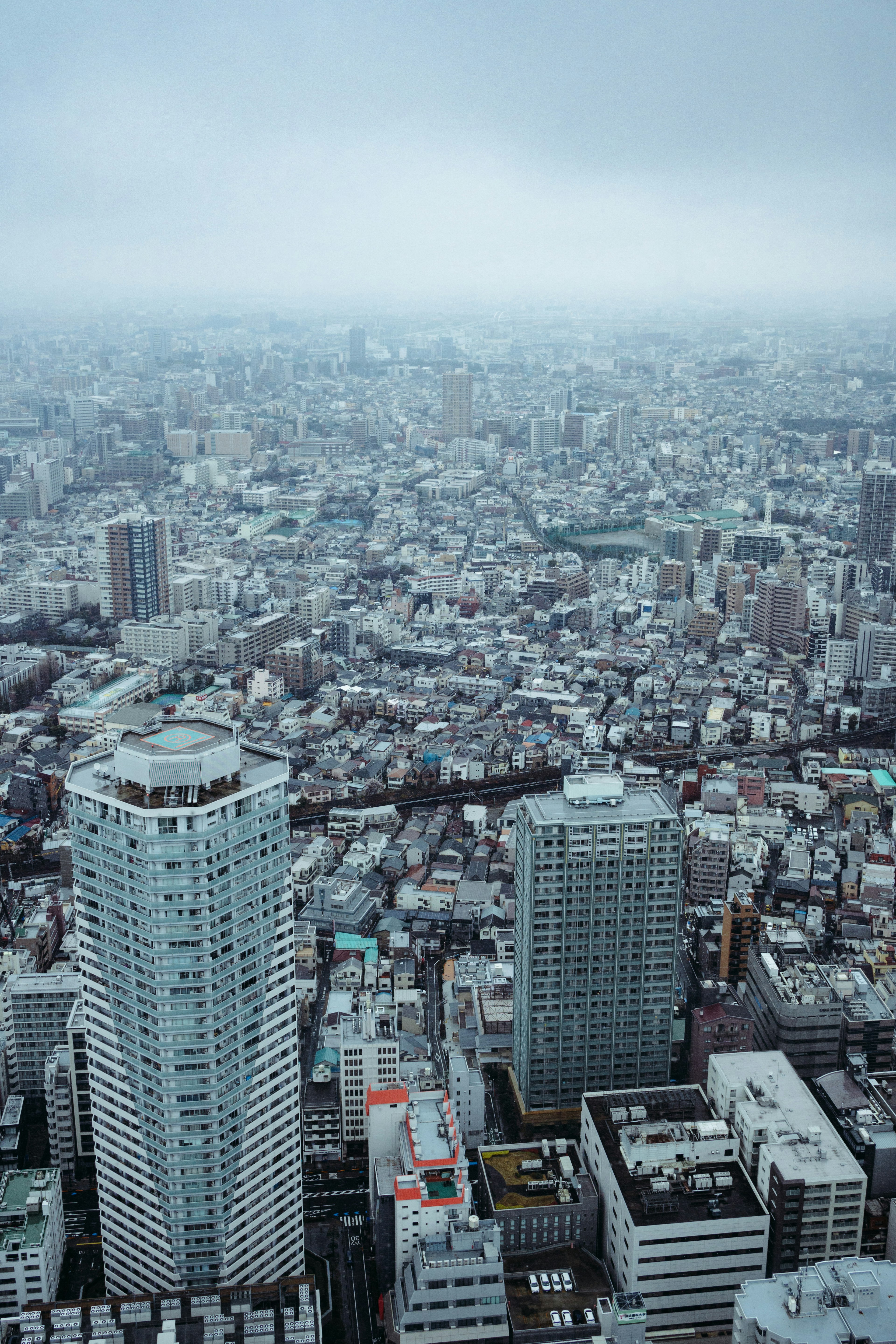 高層ビルが立ち並ぶ都市の広がりを捉えた曇りの日の風景