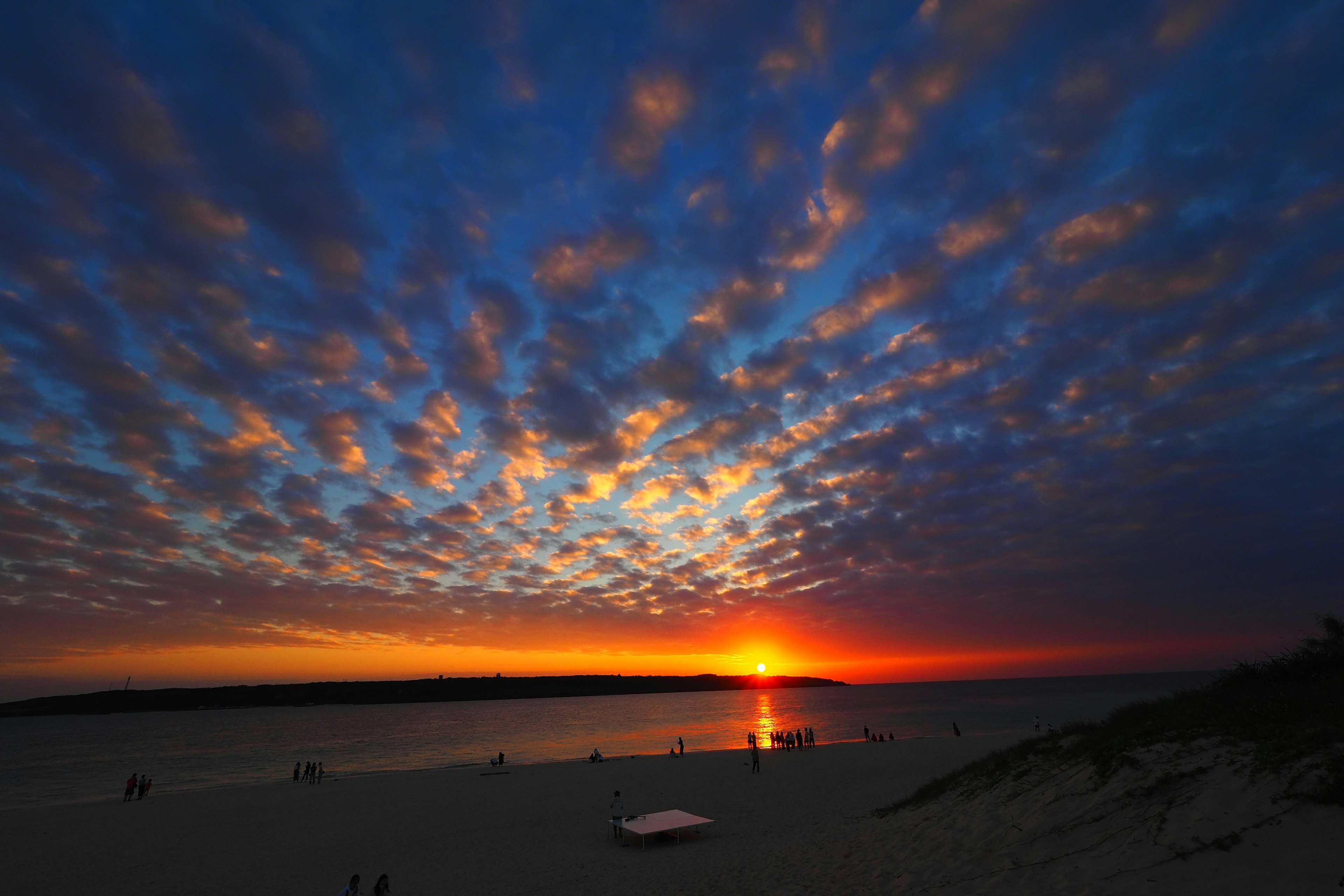 Beeindruckende Strand-Sonnenuntergangsszene mit bunten Wolken am Himmel