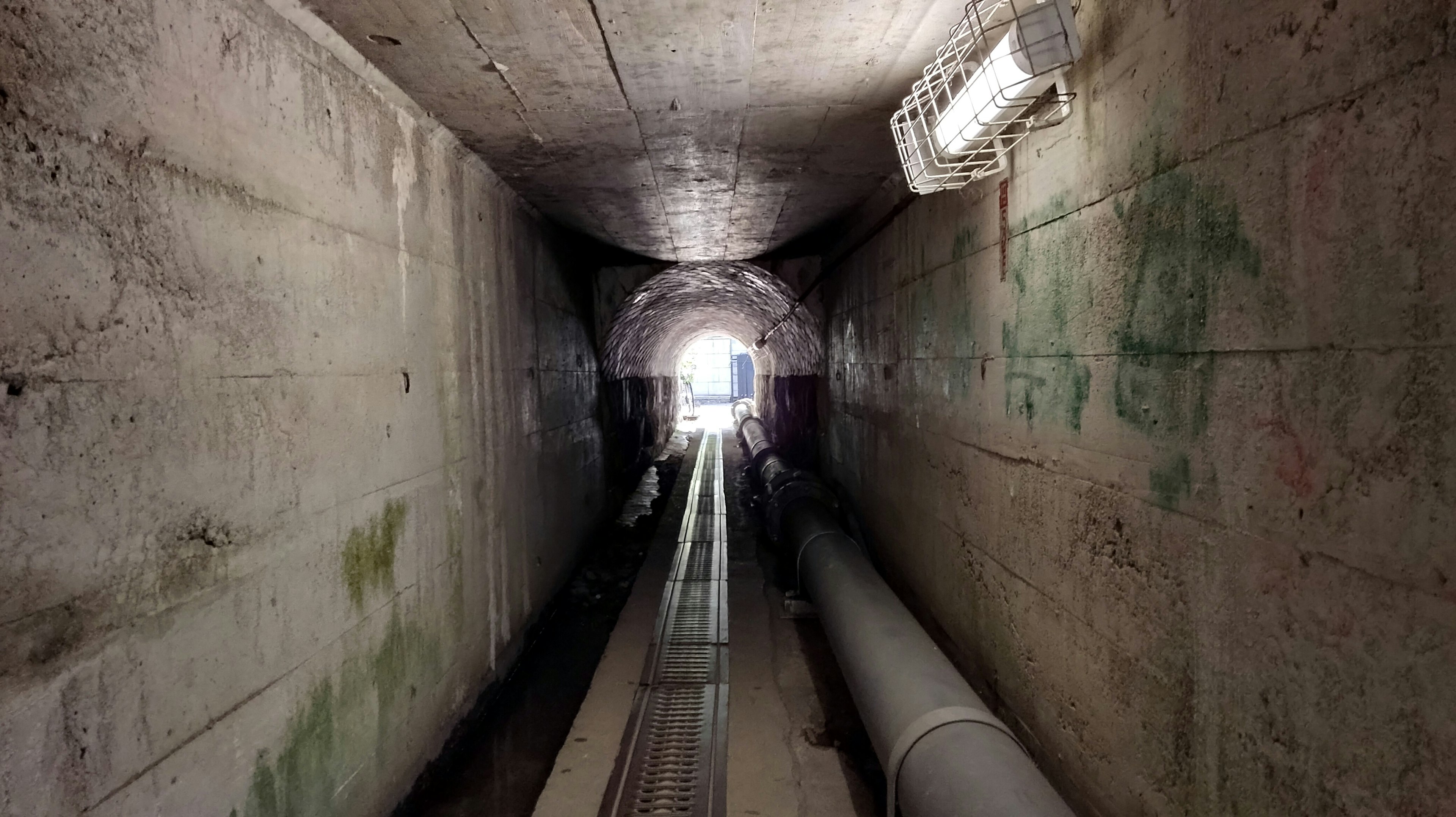 View of a tunnel leading towards a bright exit