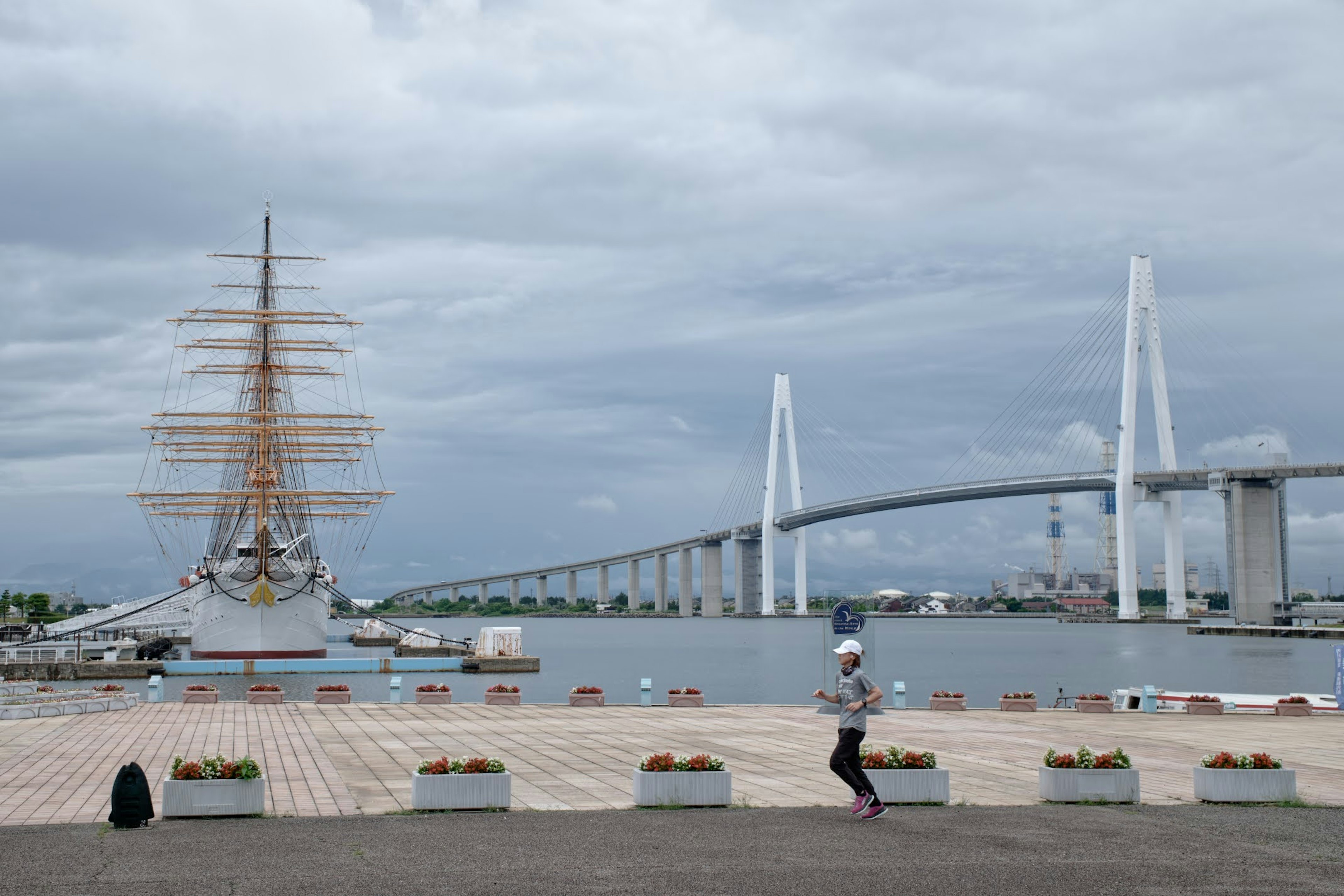 เรือใบขนาดใหญ่และสะพานสมัยใหม่ริมฝั่งน้ำ