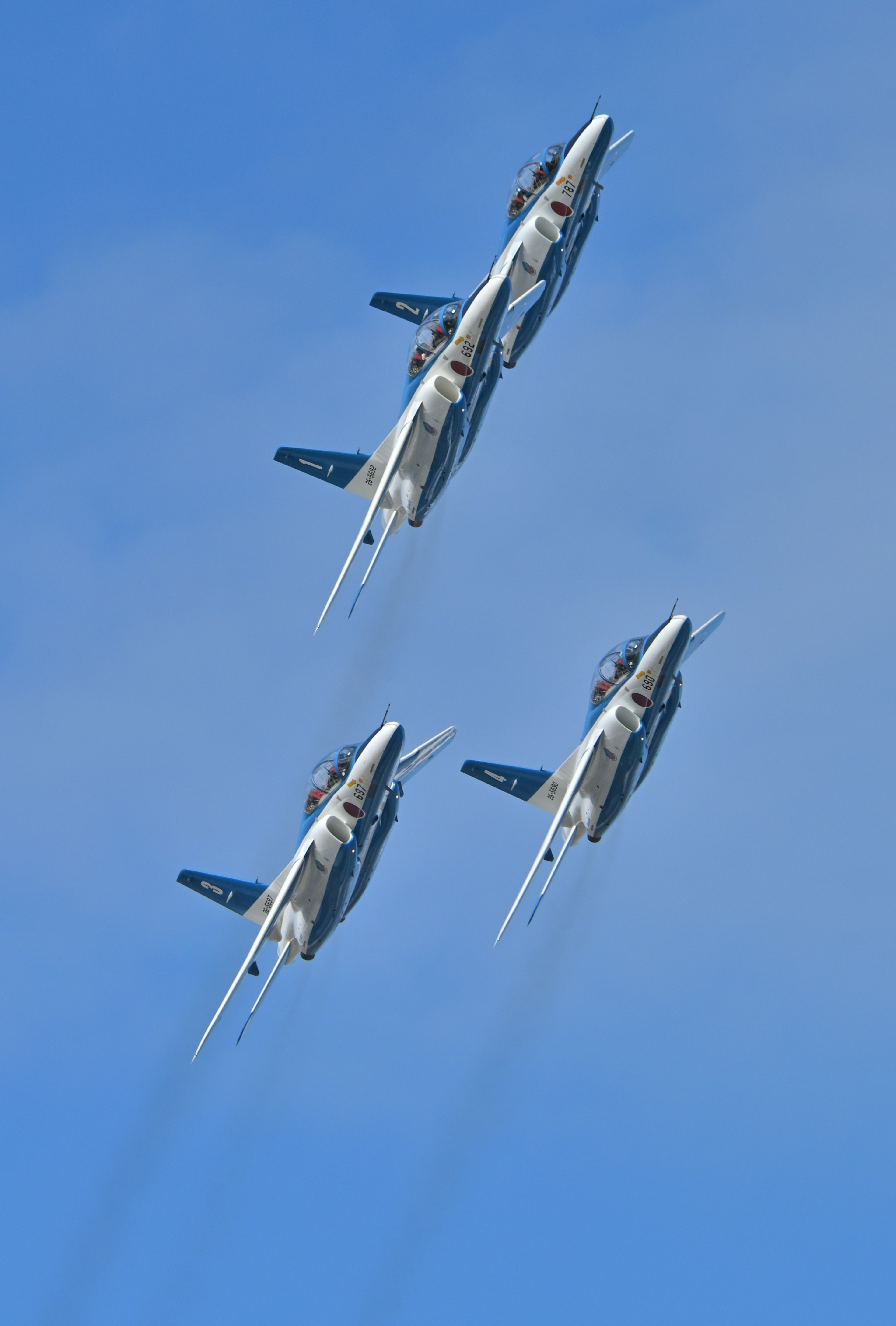 Four fighter jets flying against a blue sky