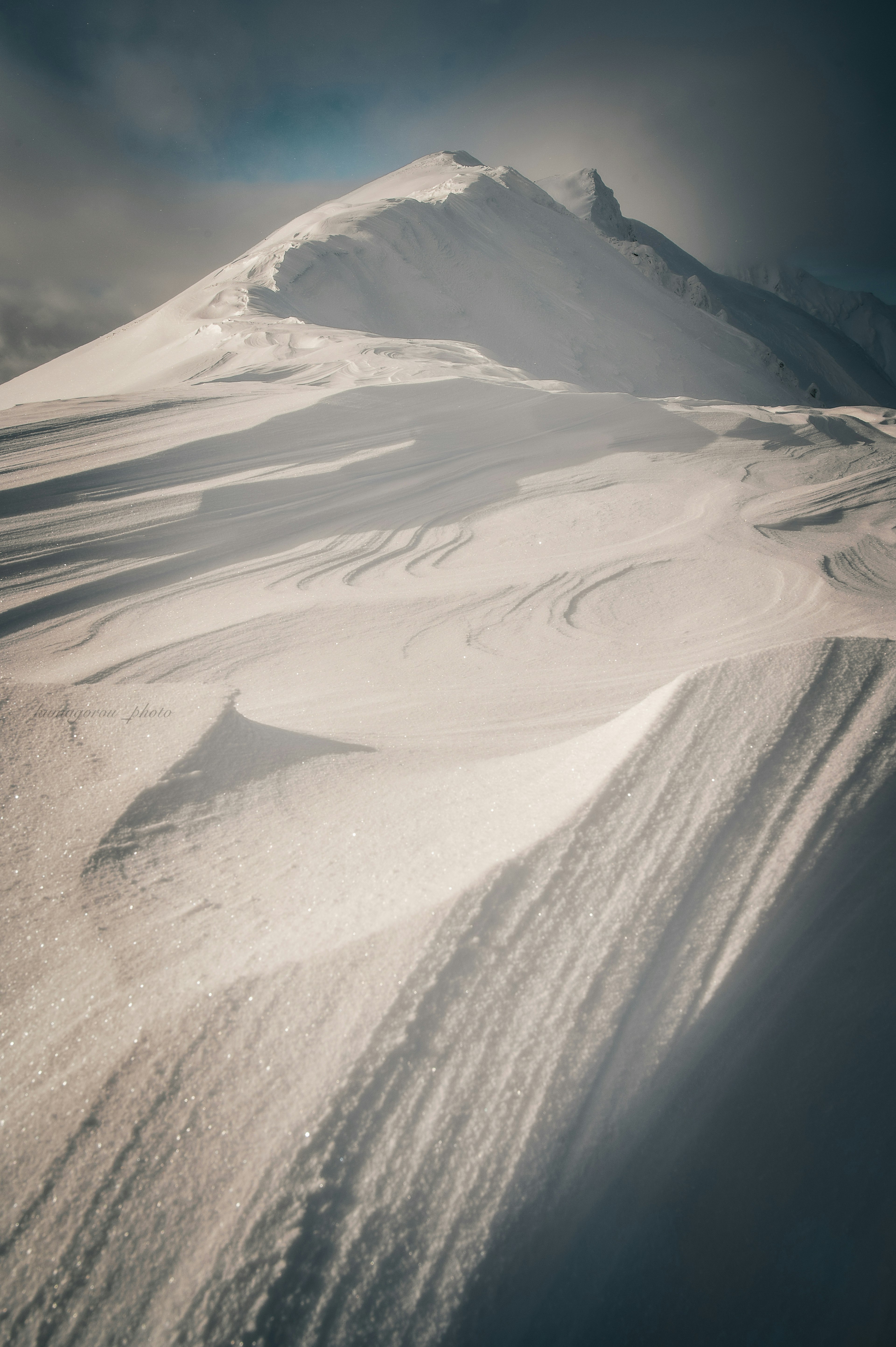 Snow-covered mountain slope with smooth curves