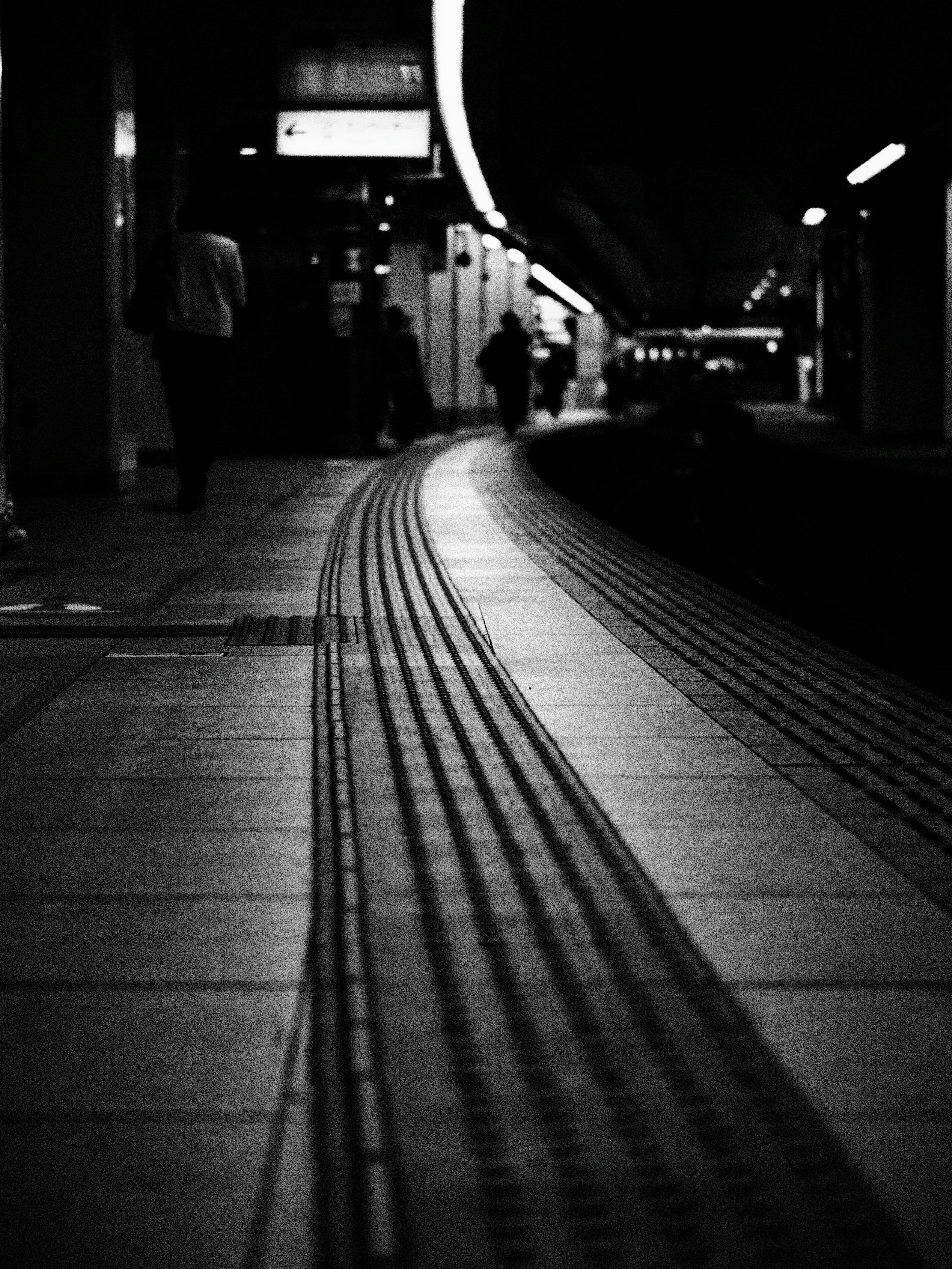 Black and white photo capturing a curved train platform