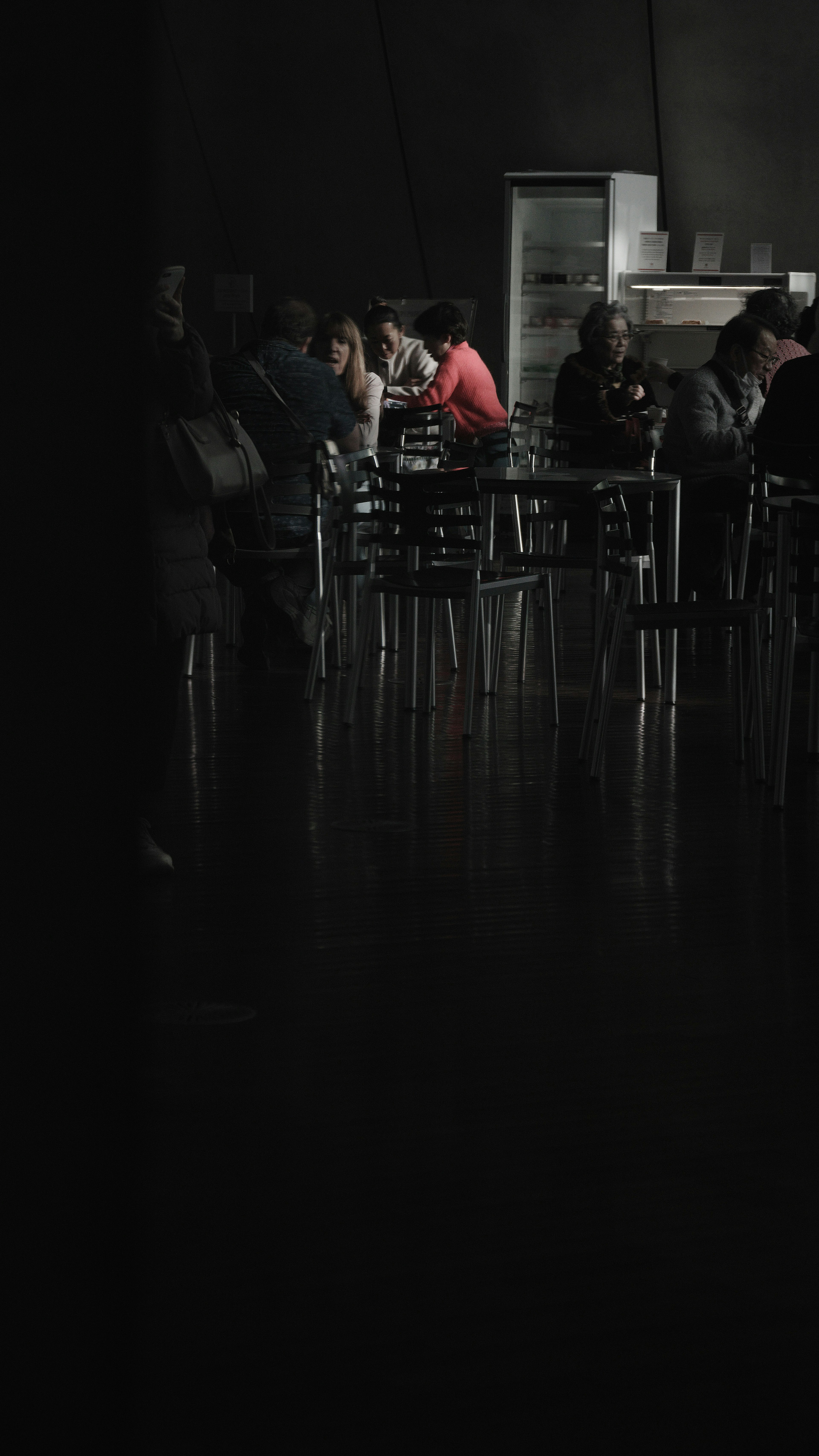 Personas reunidas en un café con poca luz