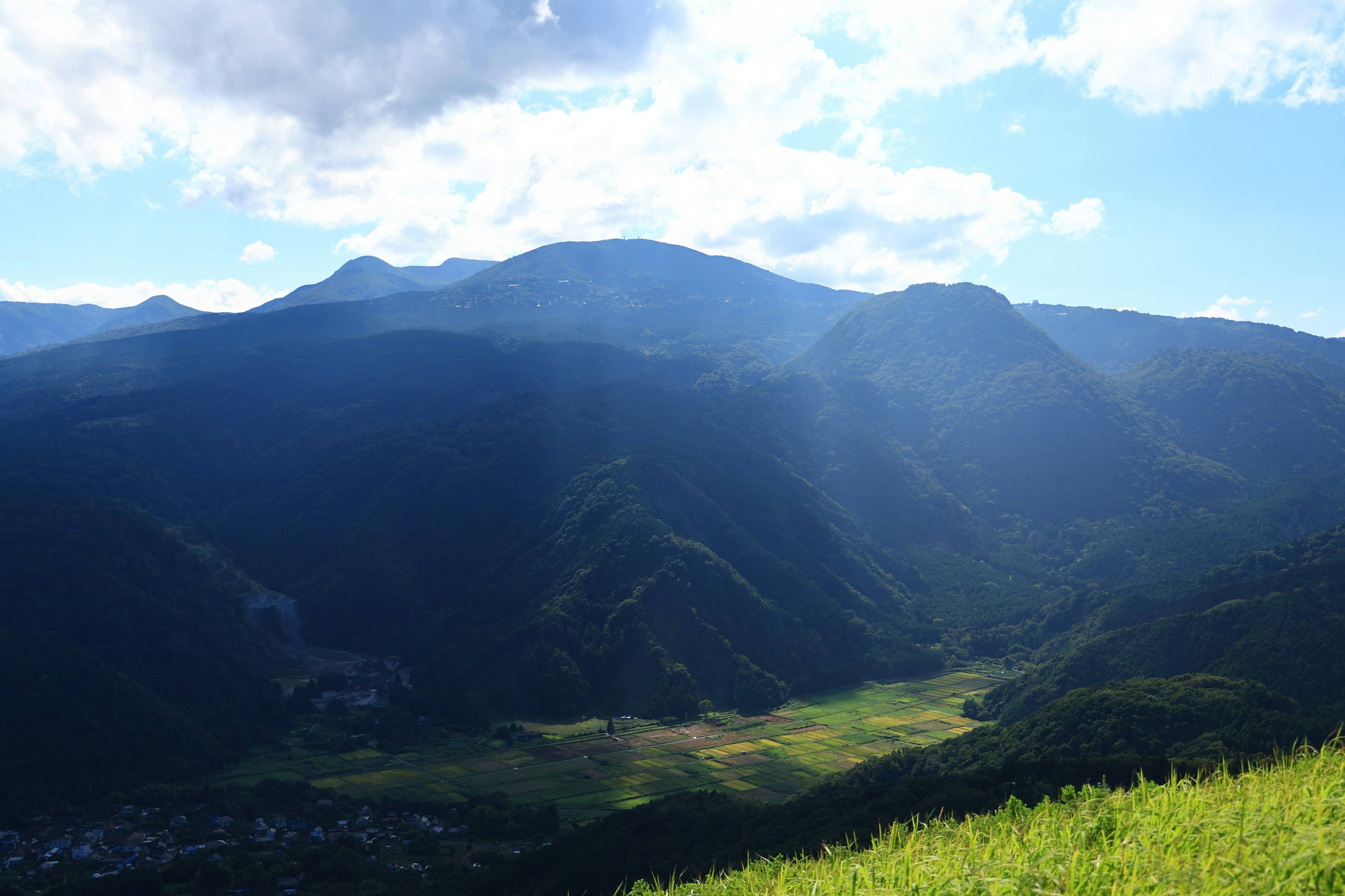 Malersiche Aussicht auf Berge mit blauem Himmel üppiges grünes Tal darunter