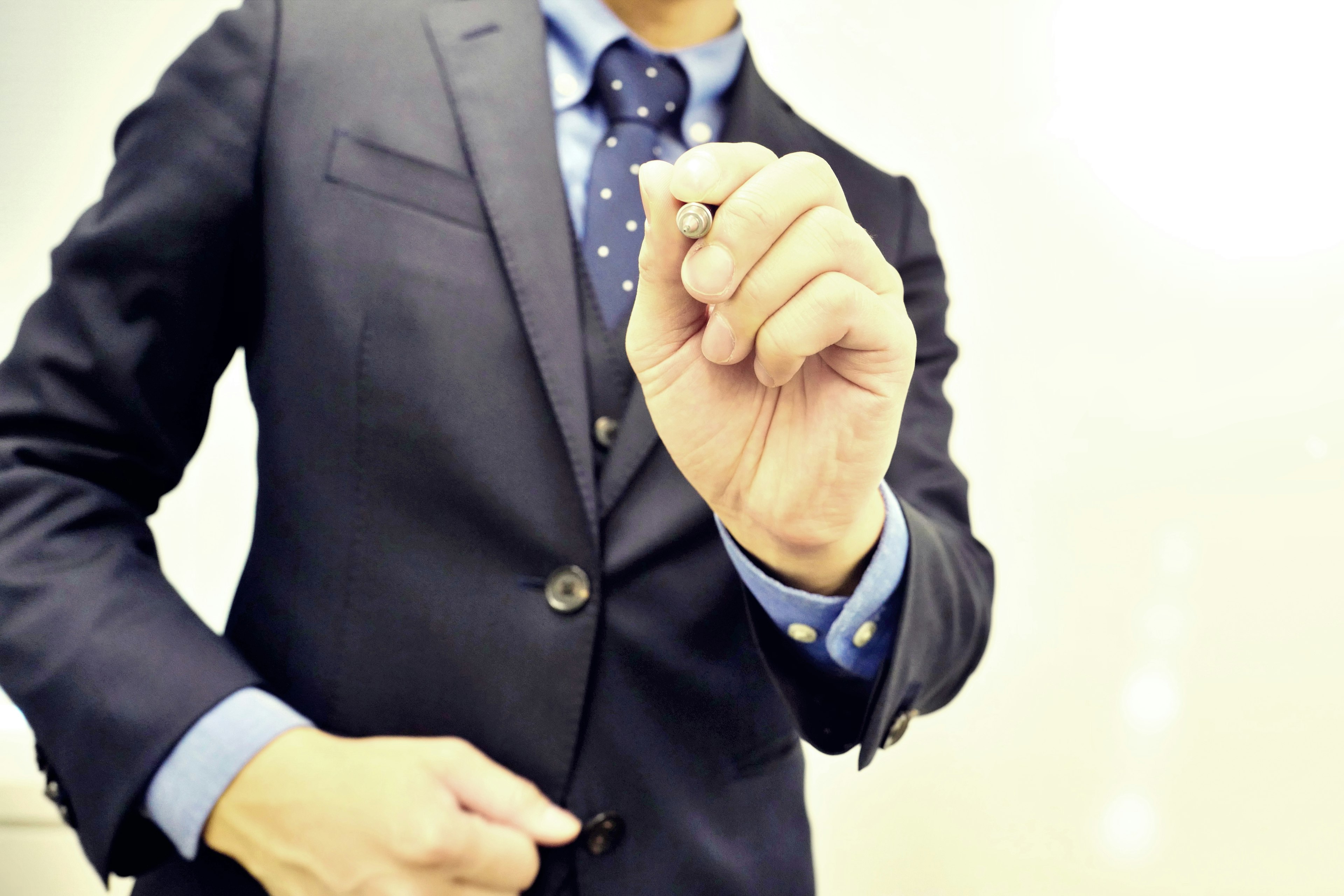 A man in a suit holding a pen