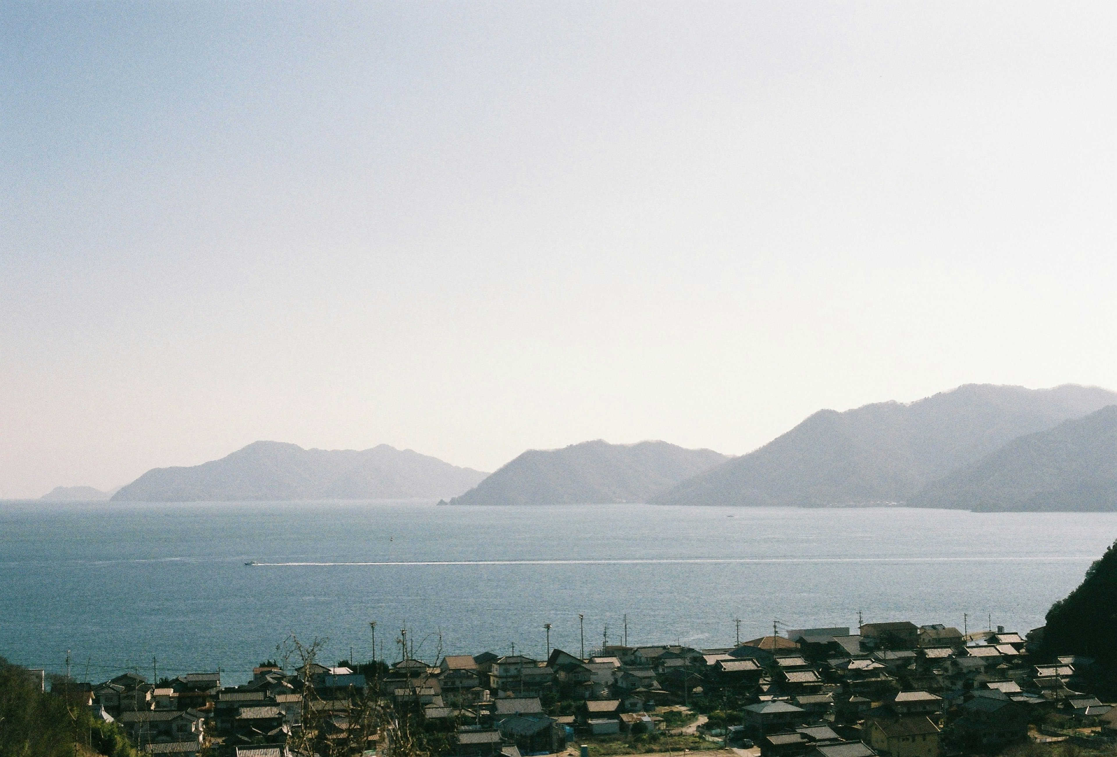 Scenic view of a coastal village with mountains in the background