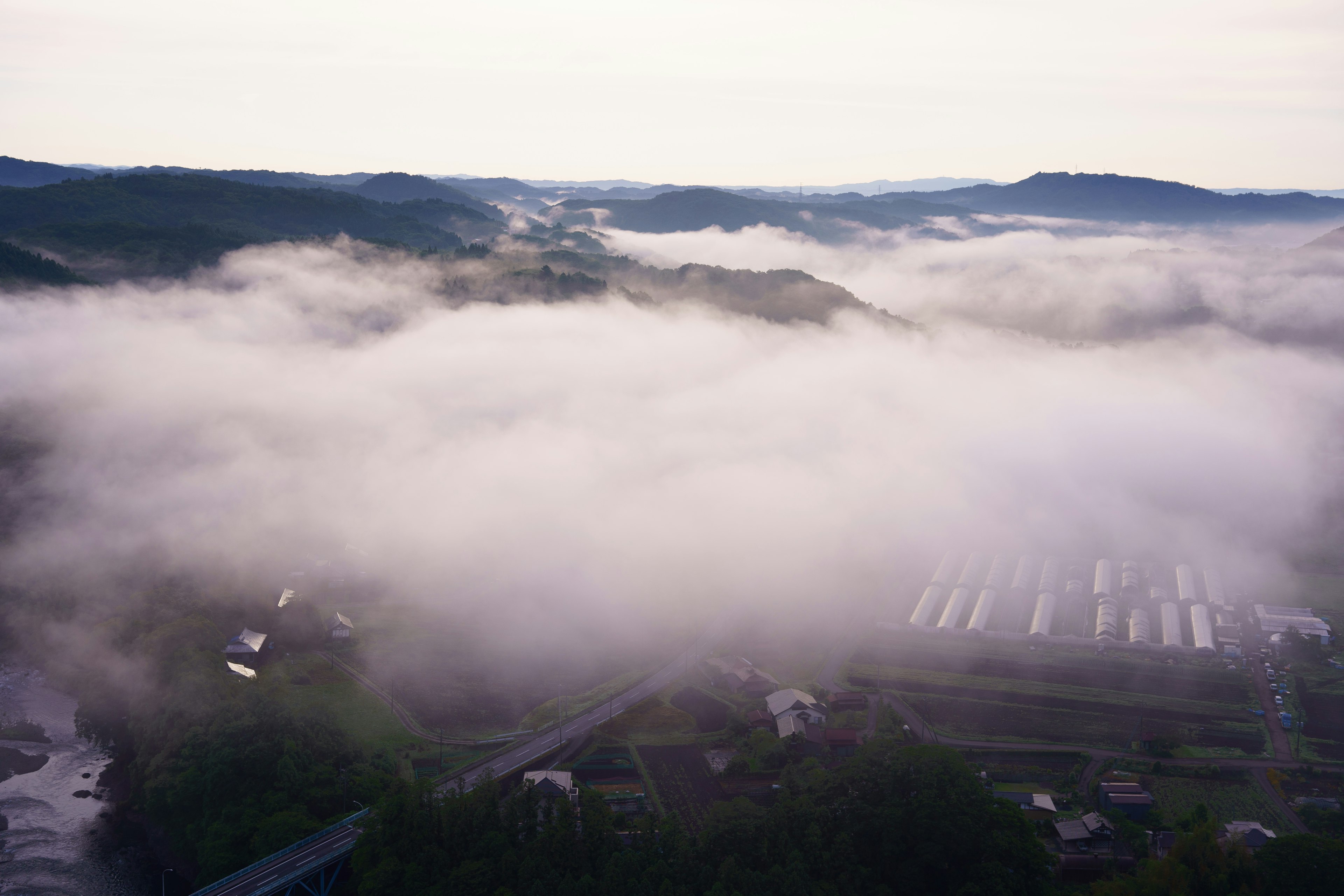 Vue aérienne de montagnes et de villages enveloppés de brouillard