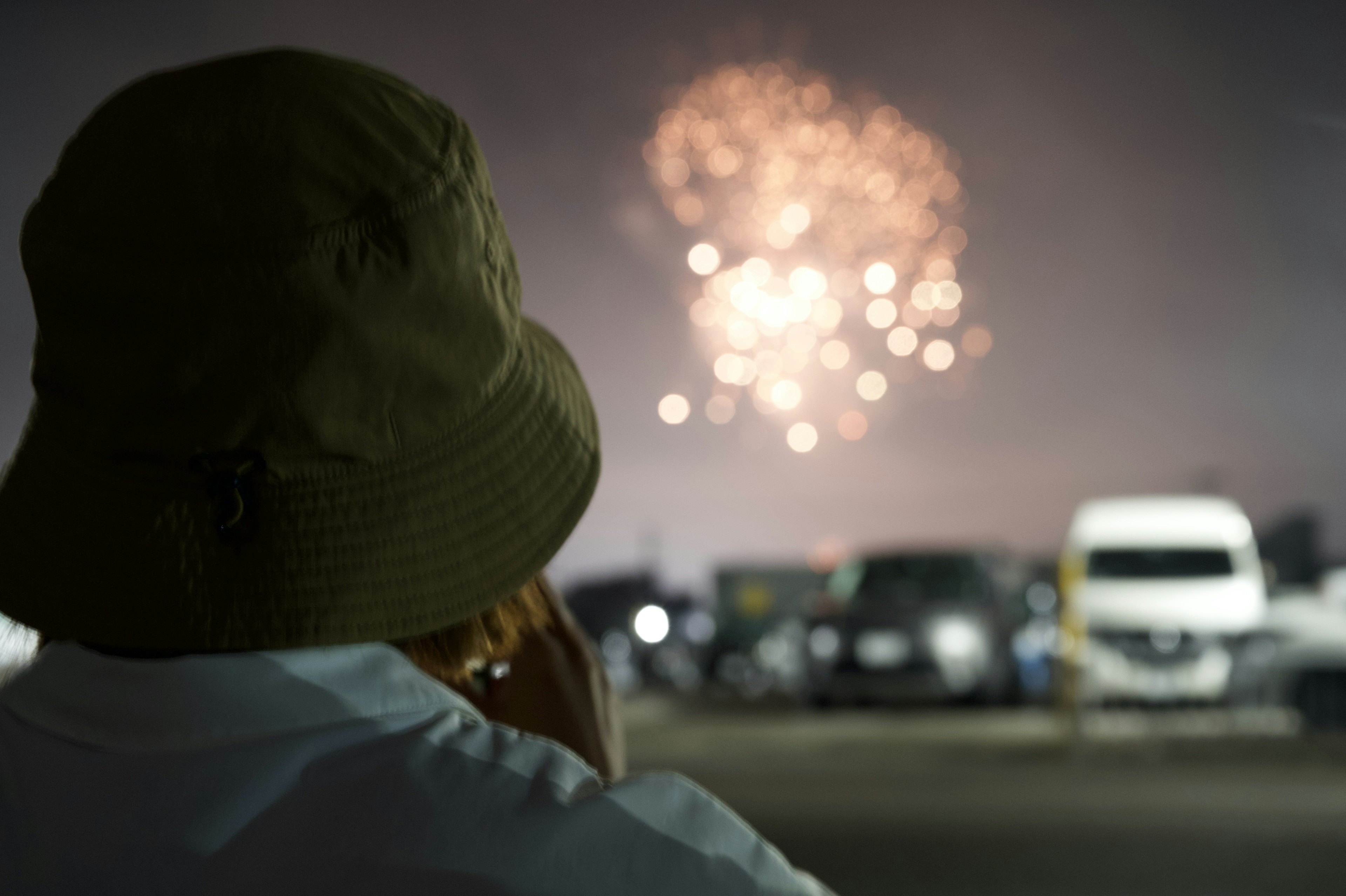 Personne portant un chapeau regardant des feux d'artifice