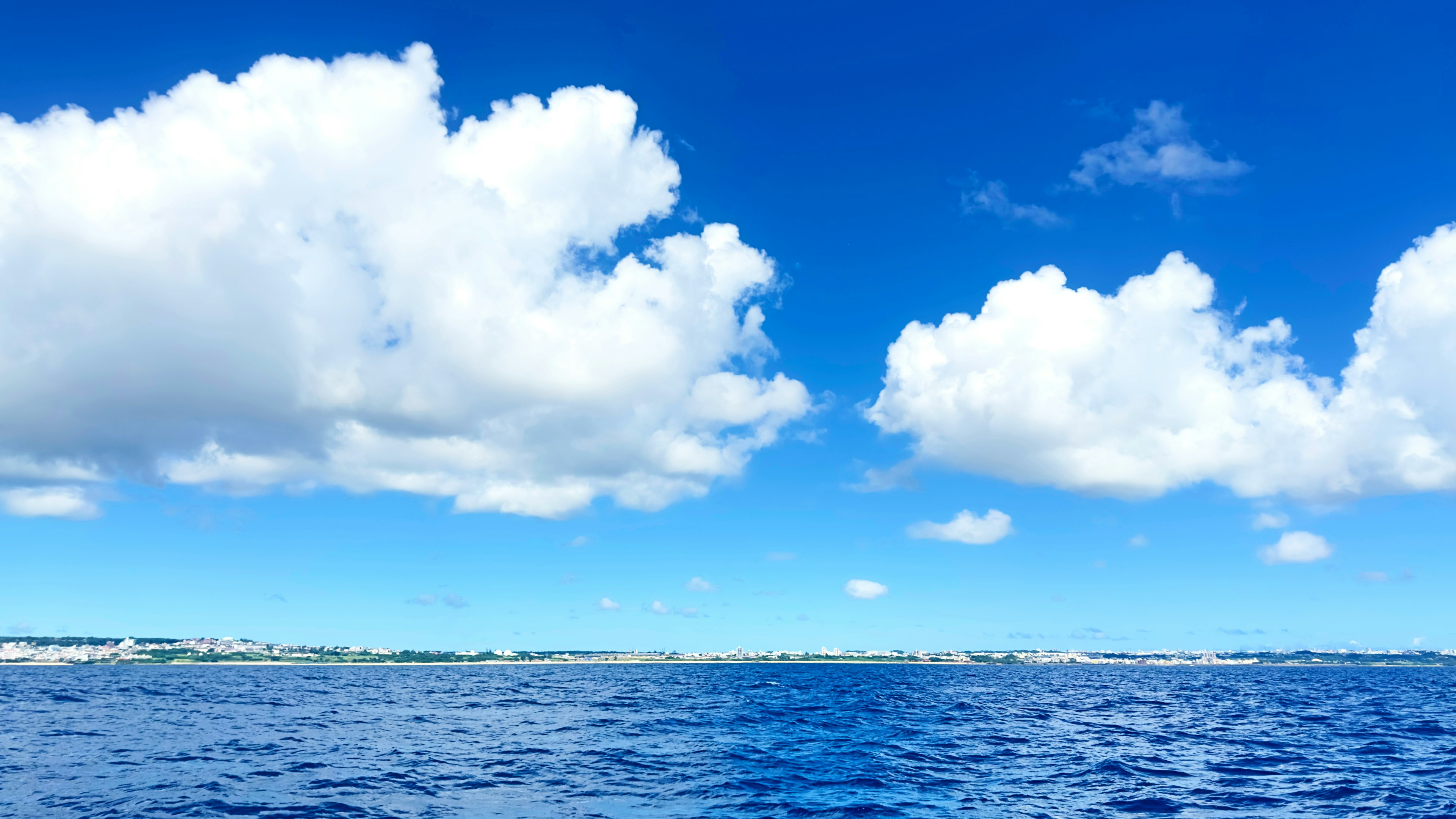 Eine wunderschöne Landschaft mit einem blauen Ozean und weißen Wolken