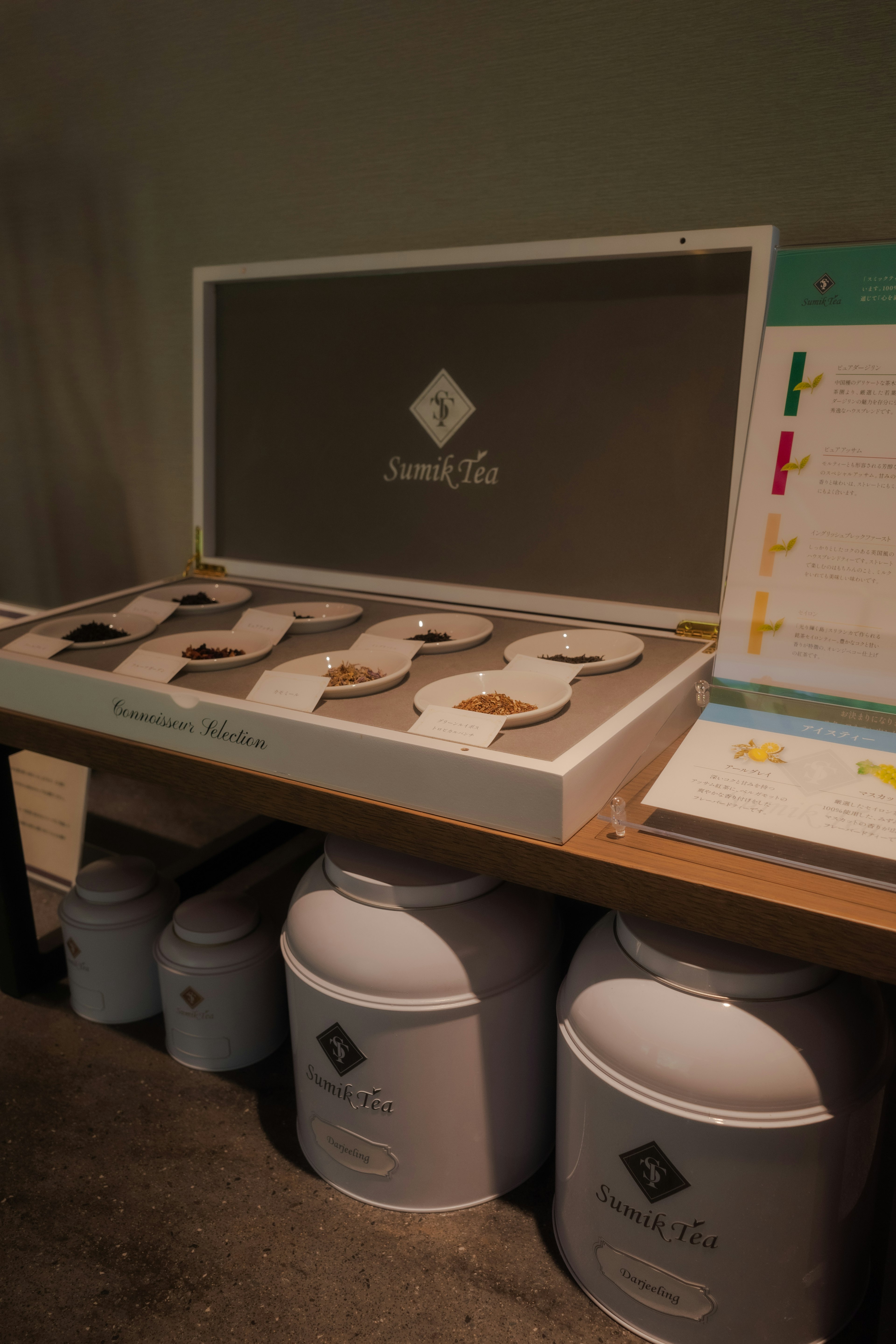 Table displaying colorful powders in white containers with a sample box behind