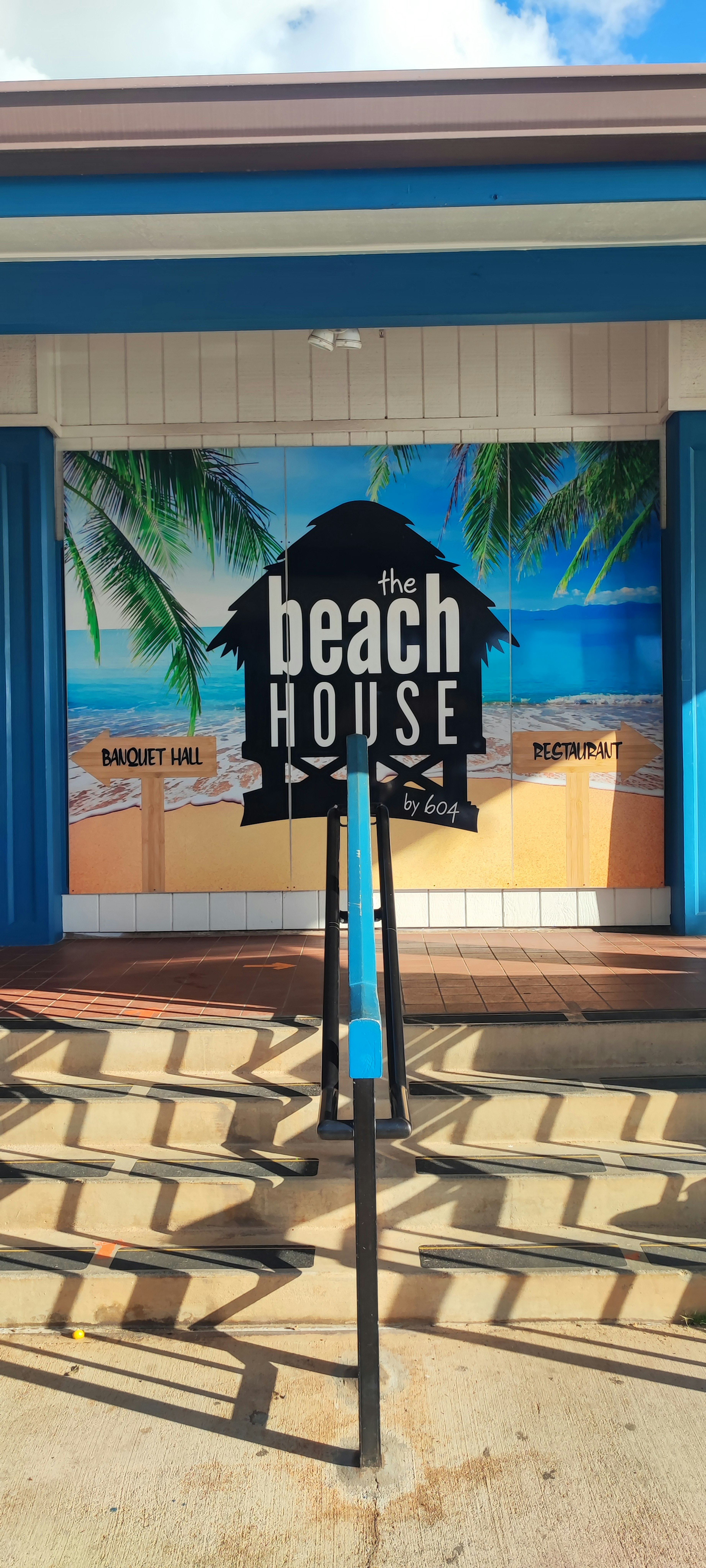 Beach House sign in front of a colorful background with palm tree illustrations