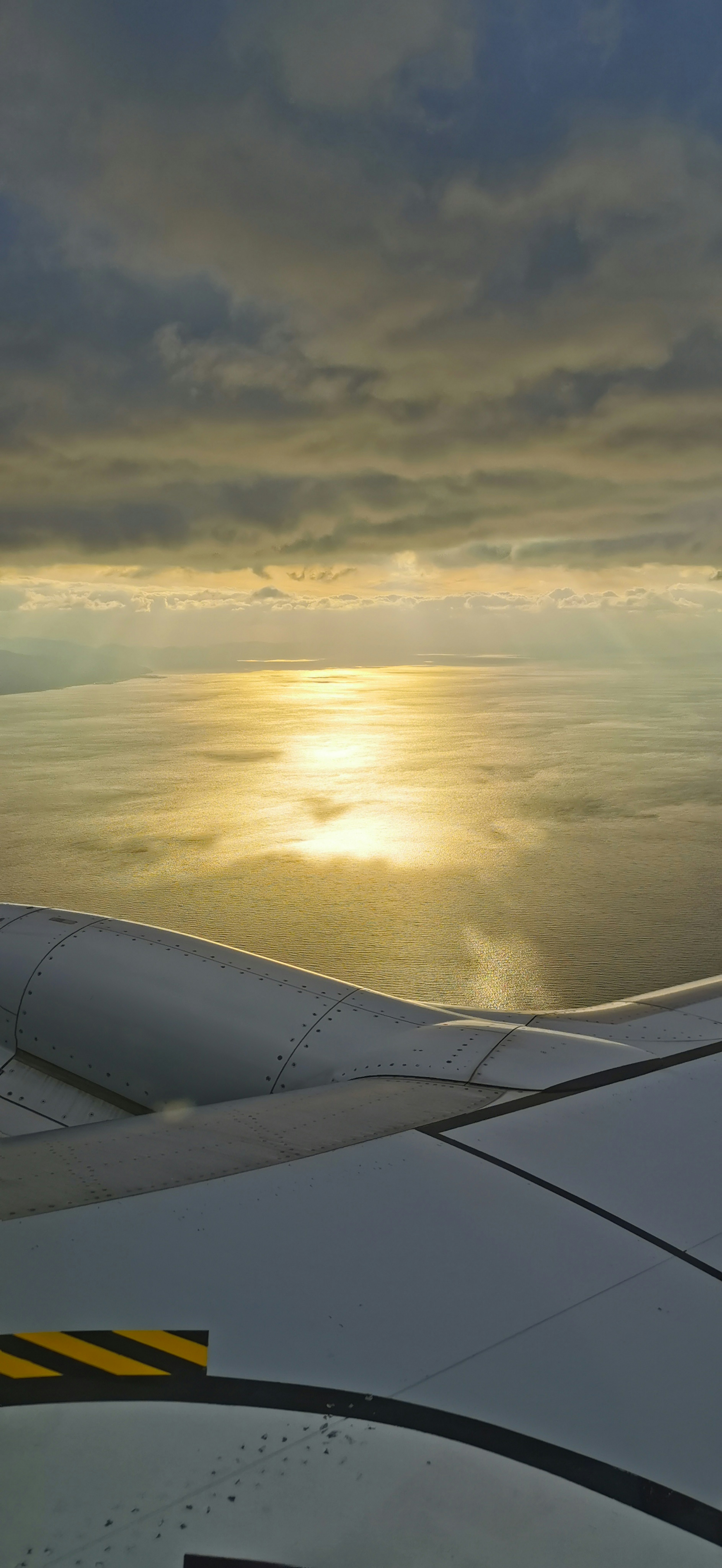 飛行機の翼から見える海と雲の美しい風景