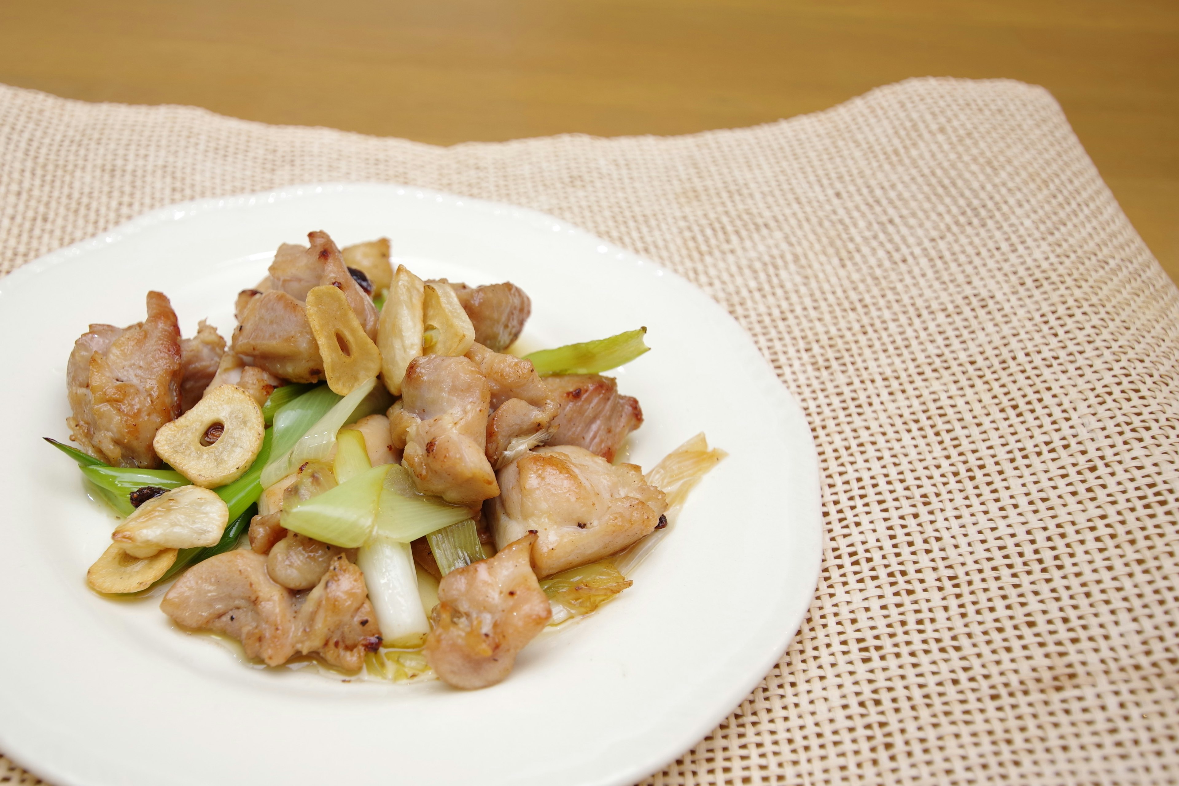 Plat de poulet sauté aux légumes sur une assiette blanche