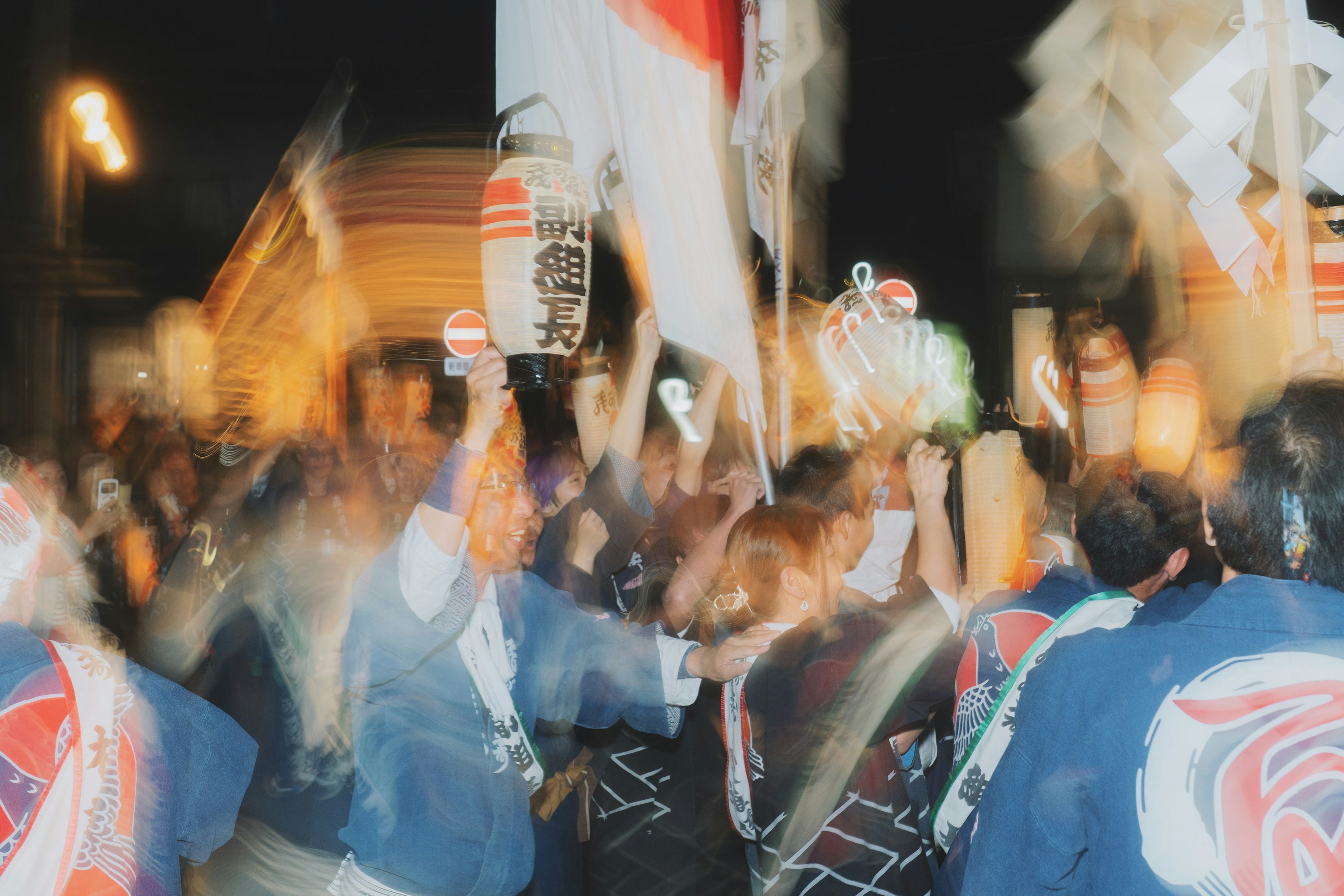 People celebrating at a night festival holding flags